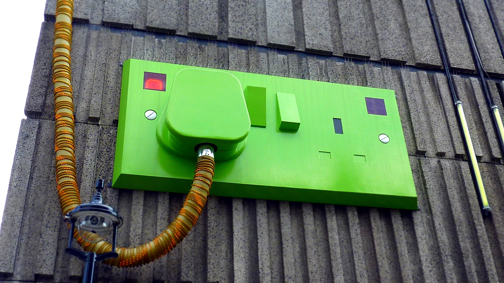Green rectangular corded machine on grey wall during daytime photo