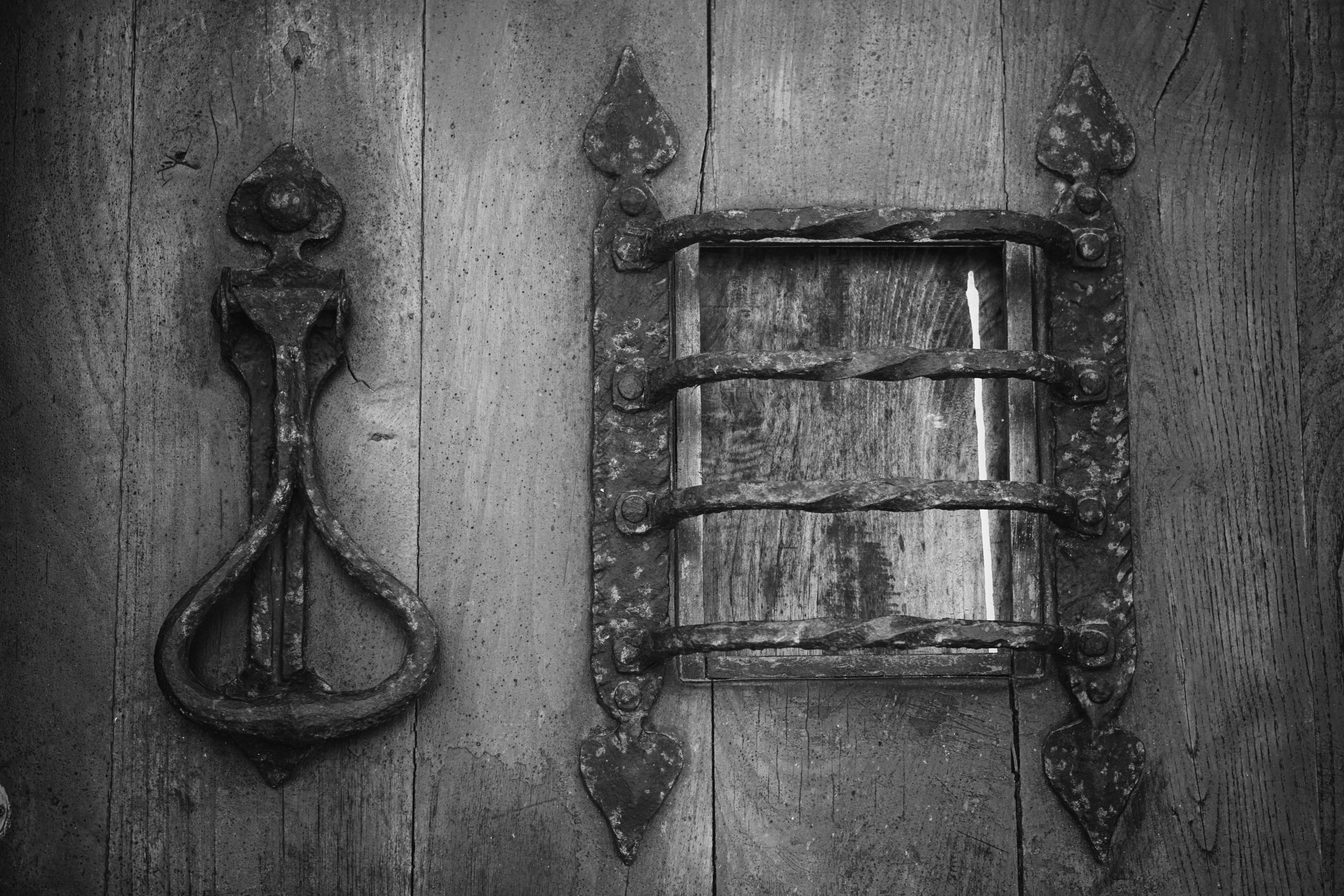 Grey metal knocker on brown wooden door photo