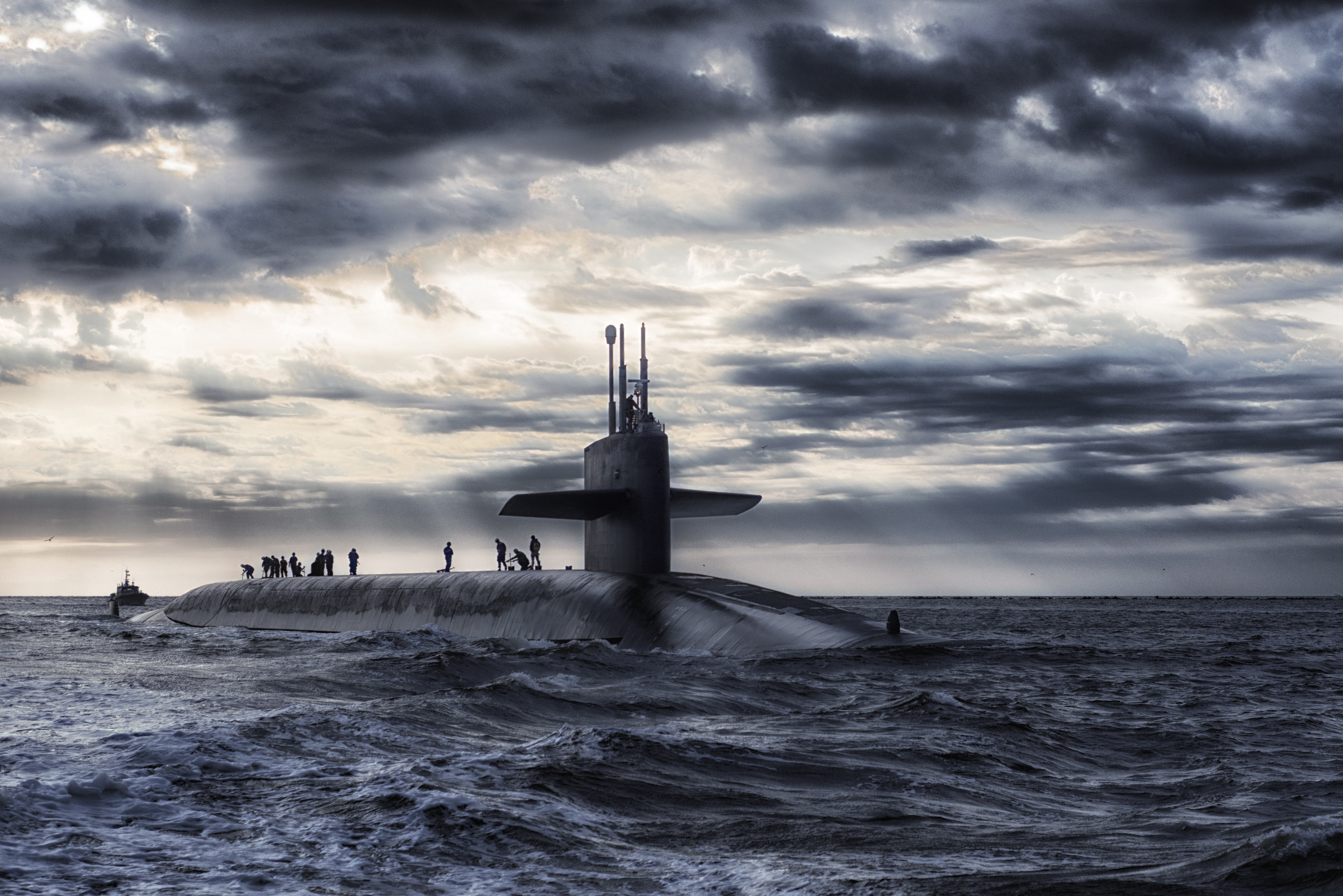 Grey submarine in body of water under cloudy sky photo