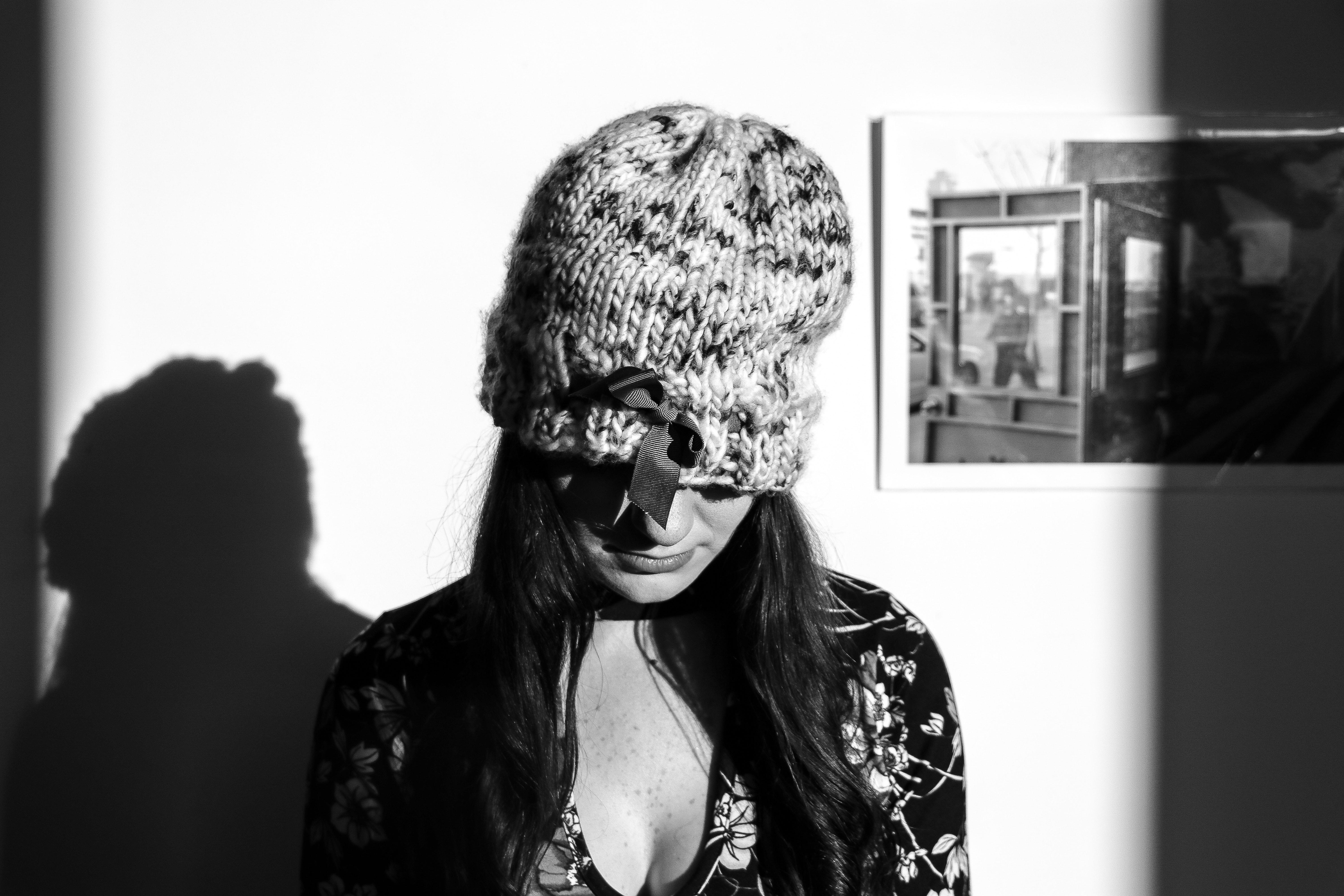 Greyscale photo of woman wearing knitted hat and floral long-sleeved top