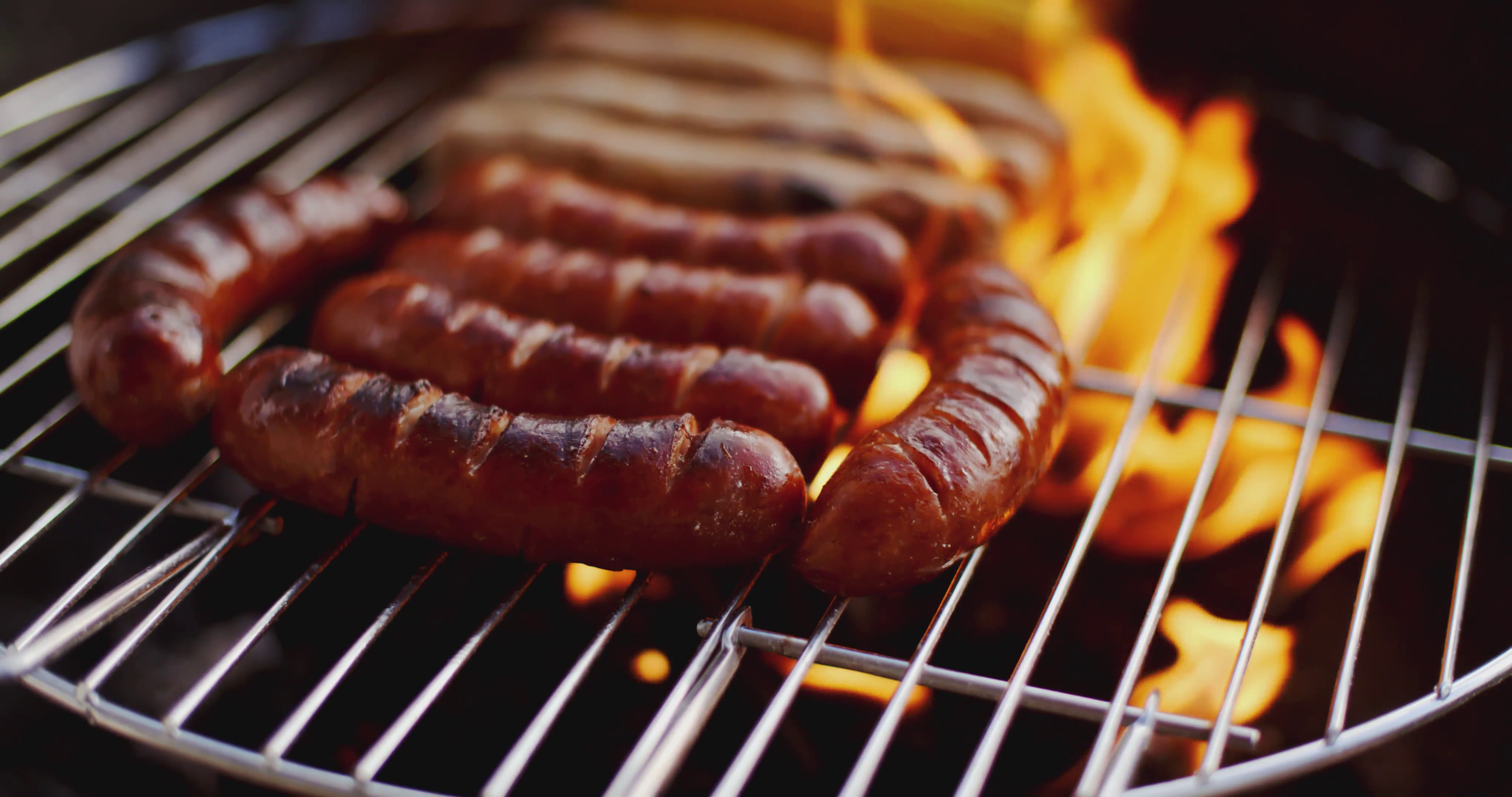 Sausages grilling over the flames Stock Video Footage - VideoBlocks