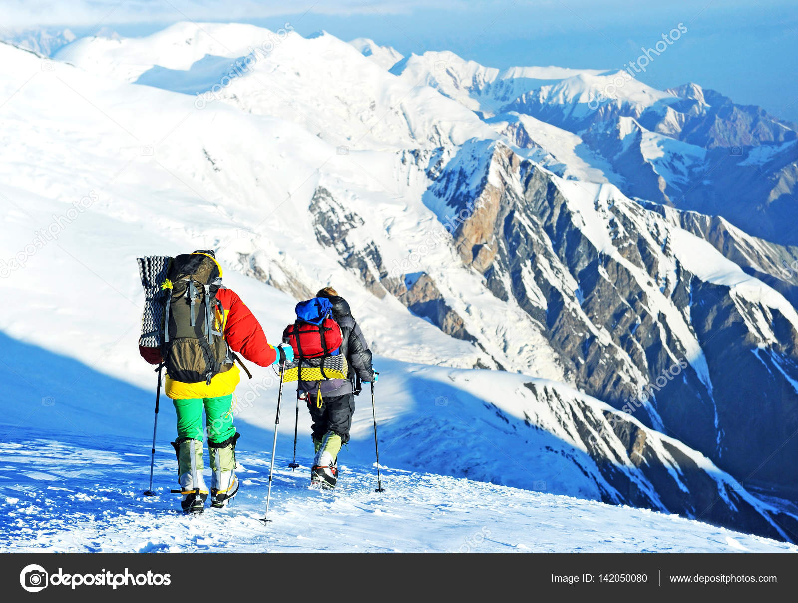 Group of climbers reaches the top of mountain peak. Climbing and ...