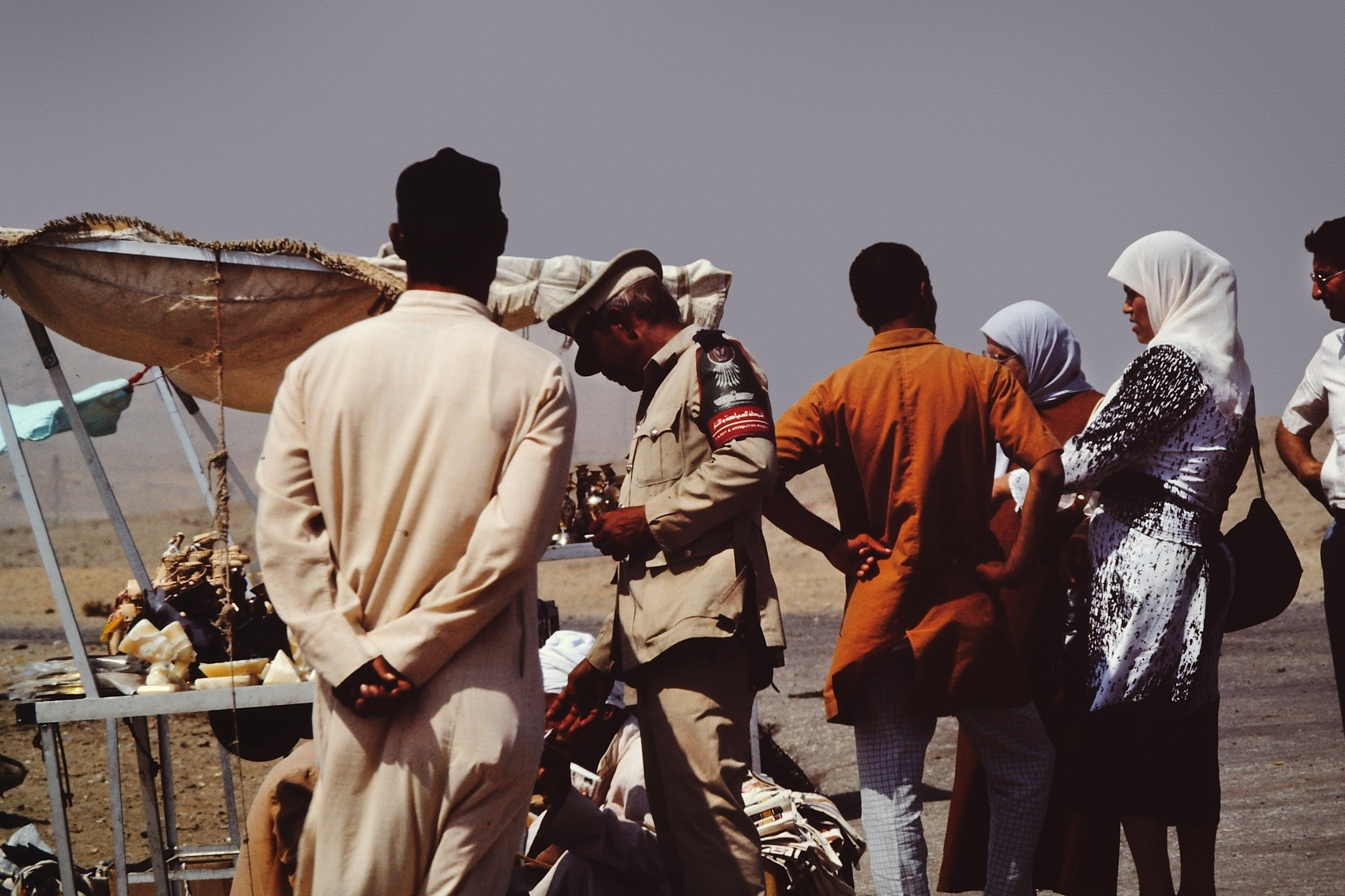 Group of people on desert beside brown tent photo