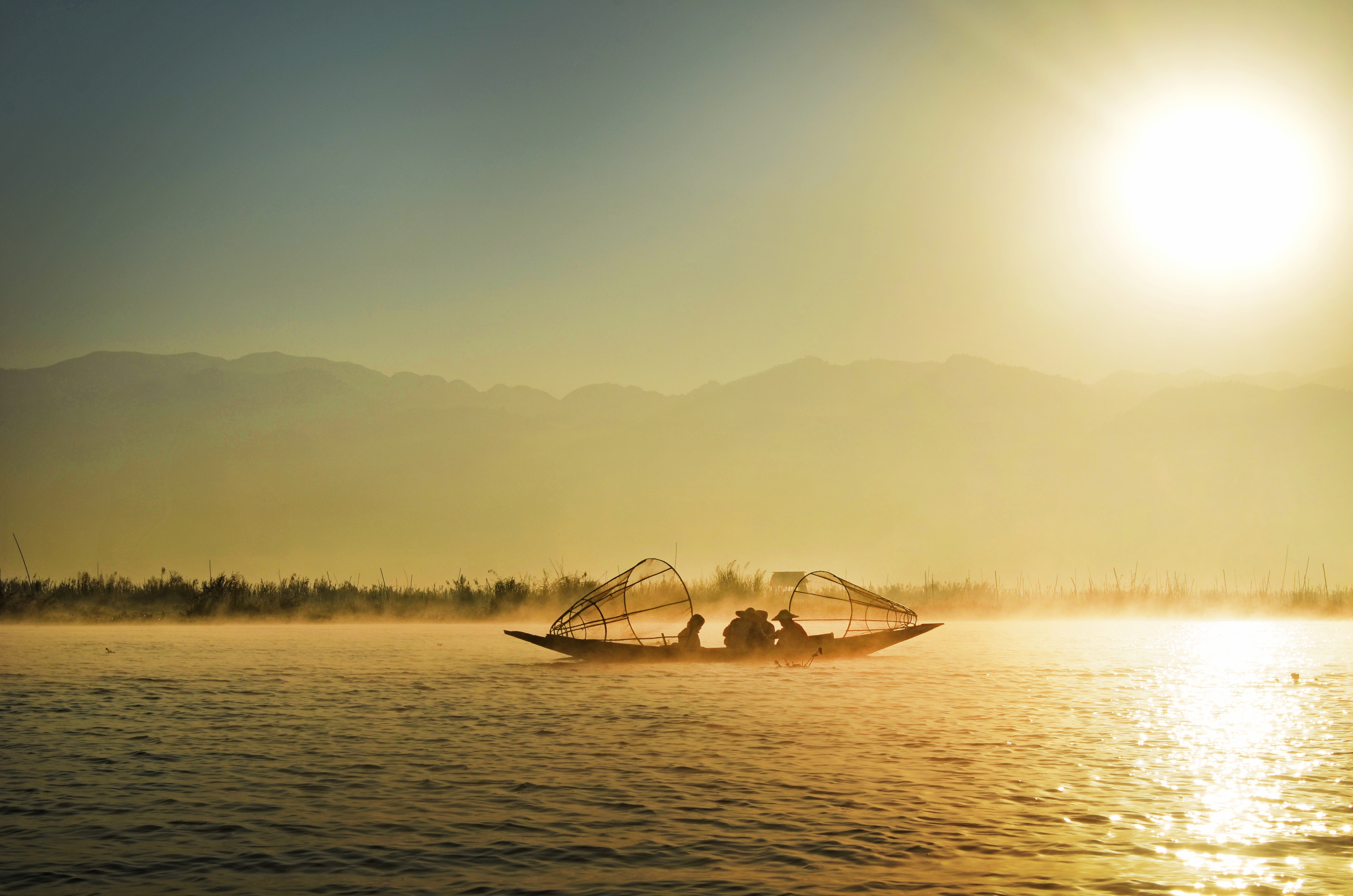 Group of people riding boat in the middle of water during sunrise photo