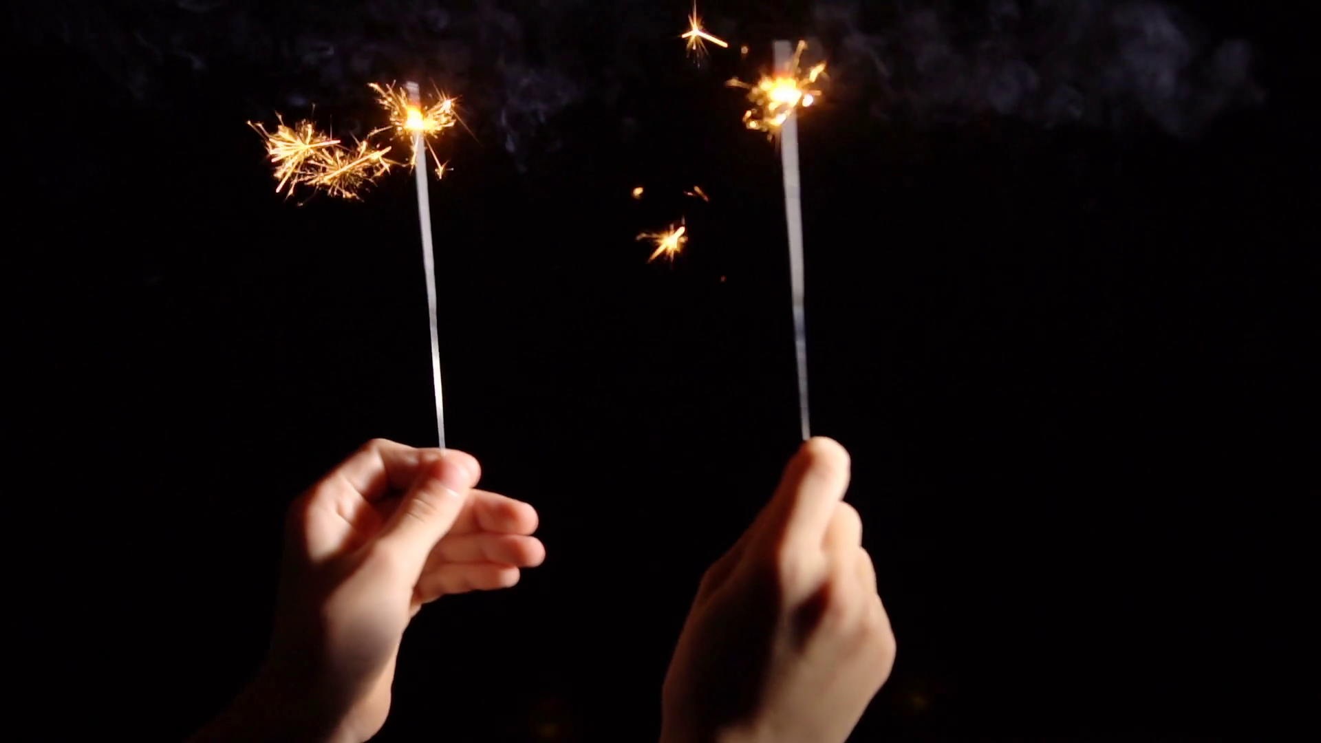 Burning sparklers in hand. New Year's fireworks in the dark. Slow ...