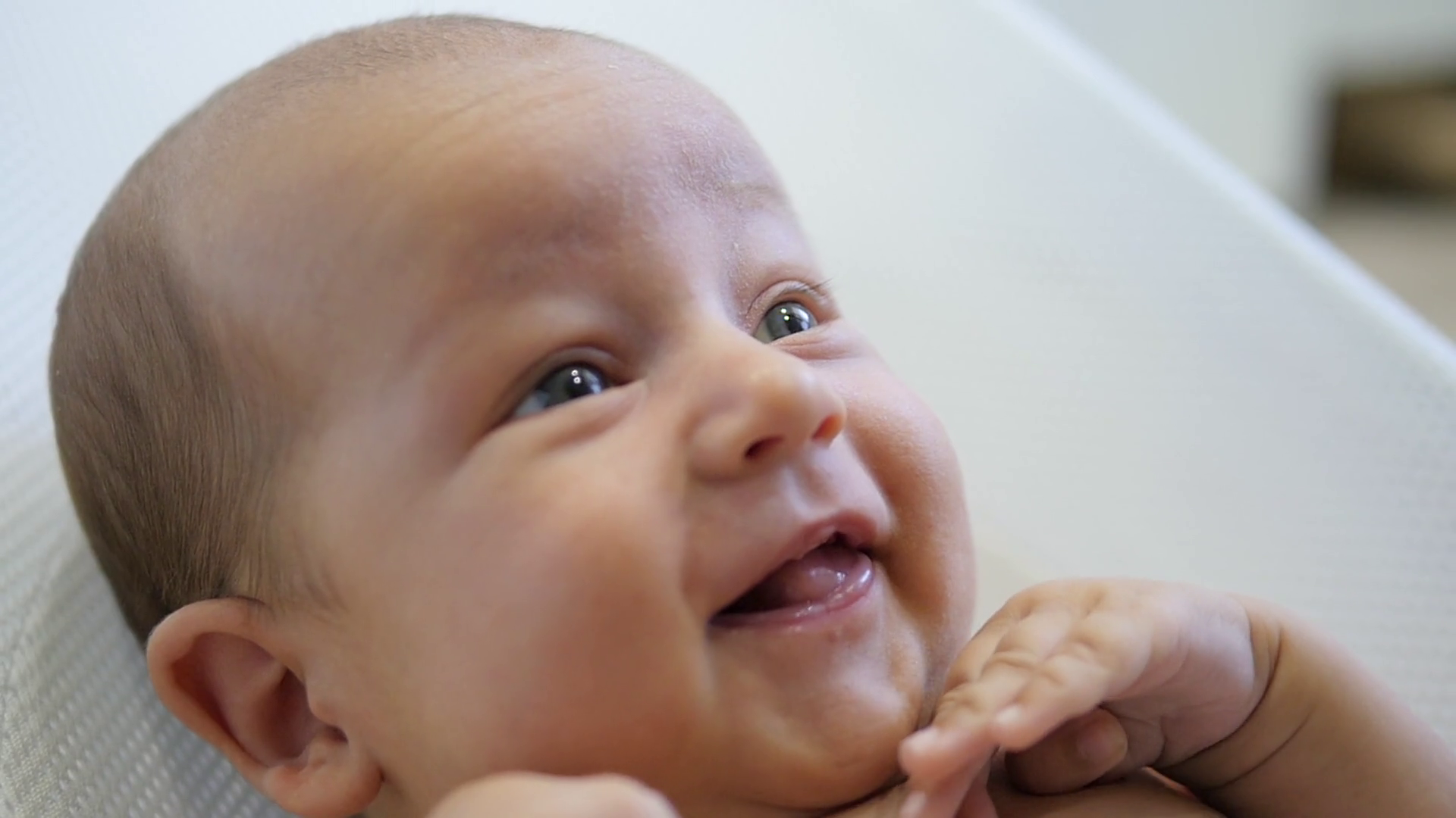 Close up portrait of amazed happy baby smiling and moving hand ...