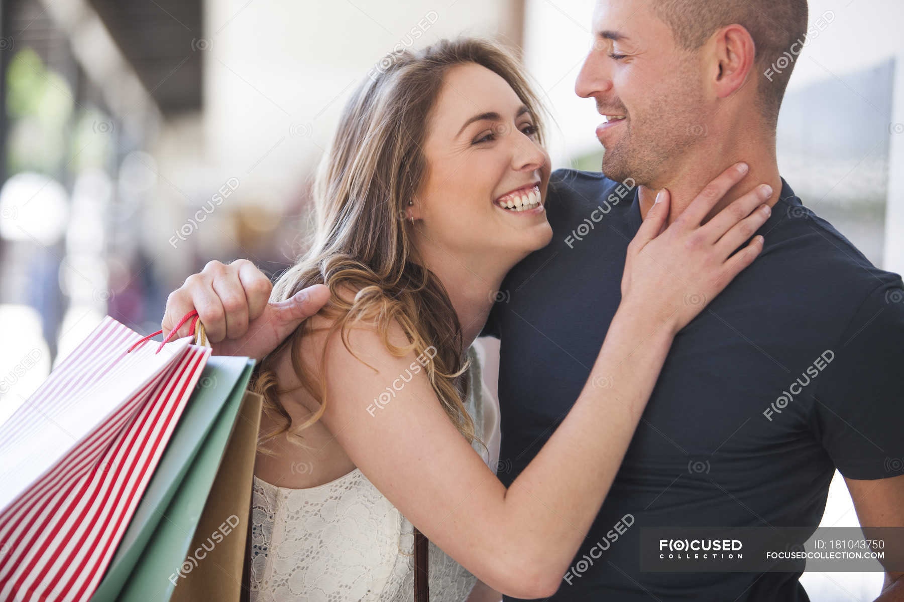 Happy couple with shopping bags hugging — Stock Photo | #181043750
