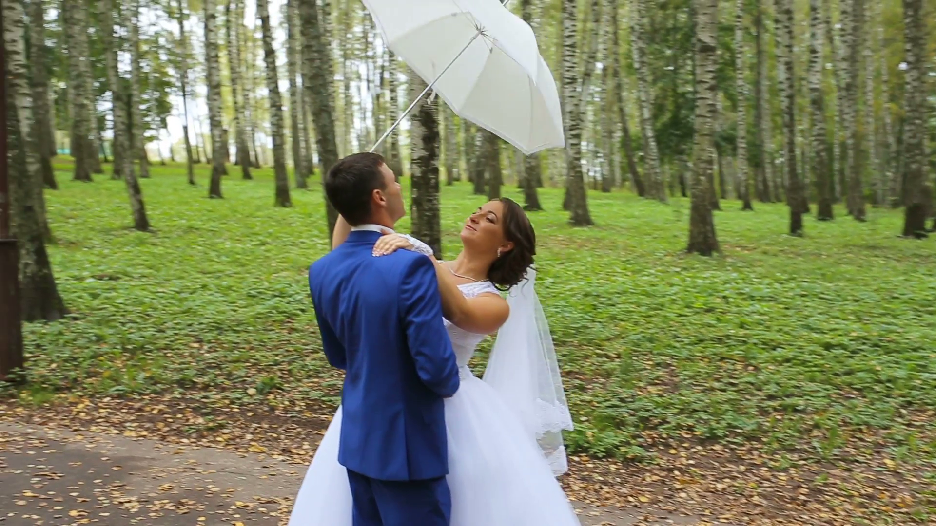 Newlyweds in a park with white umbrella.Wedding concept. Happy ...