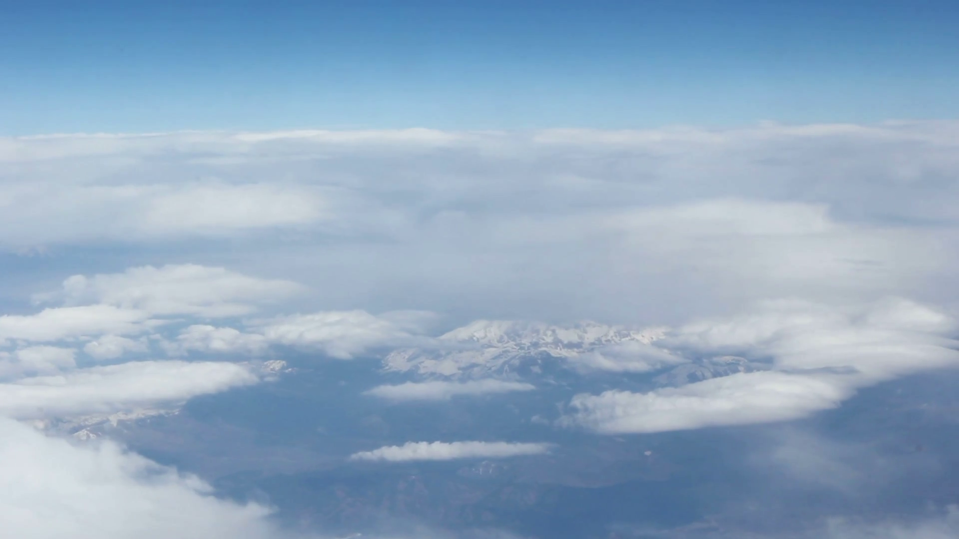 View from the clouds to the snow-capped mountains. Shooting from ...