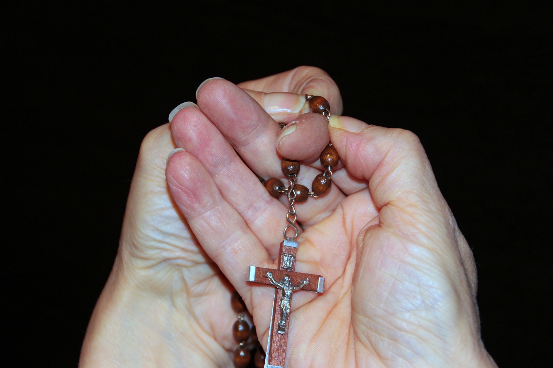 Holding a cross on string of beads photo