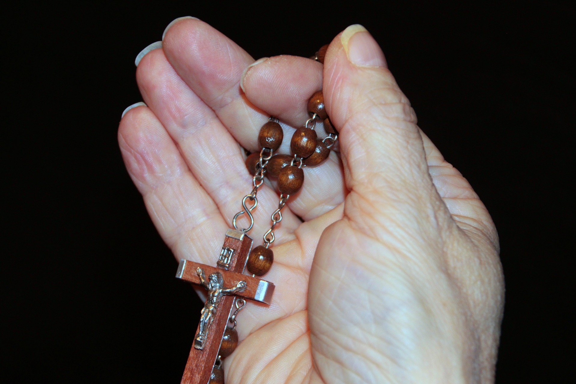 Holding string of beads and cross in hand photo