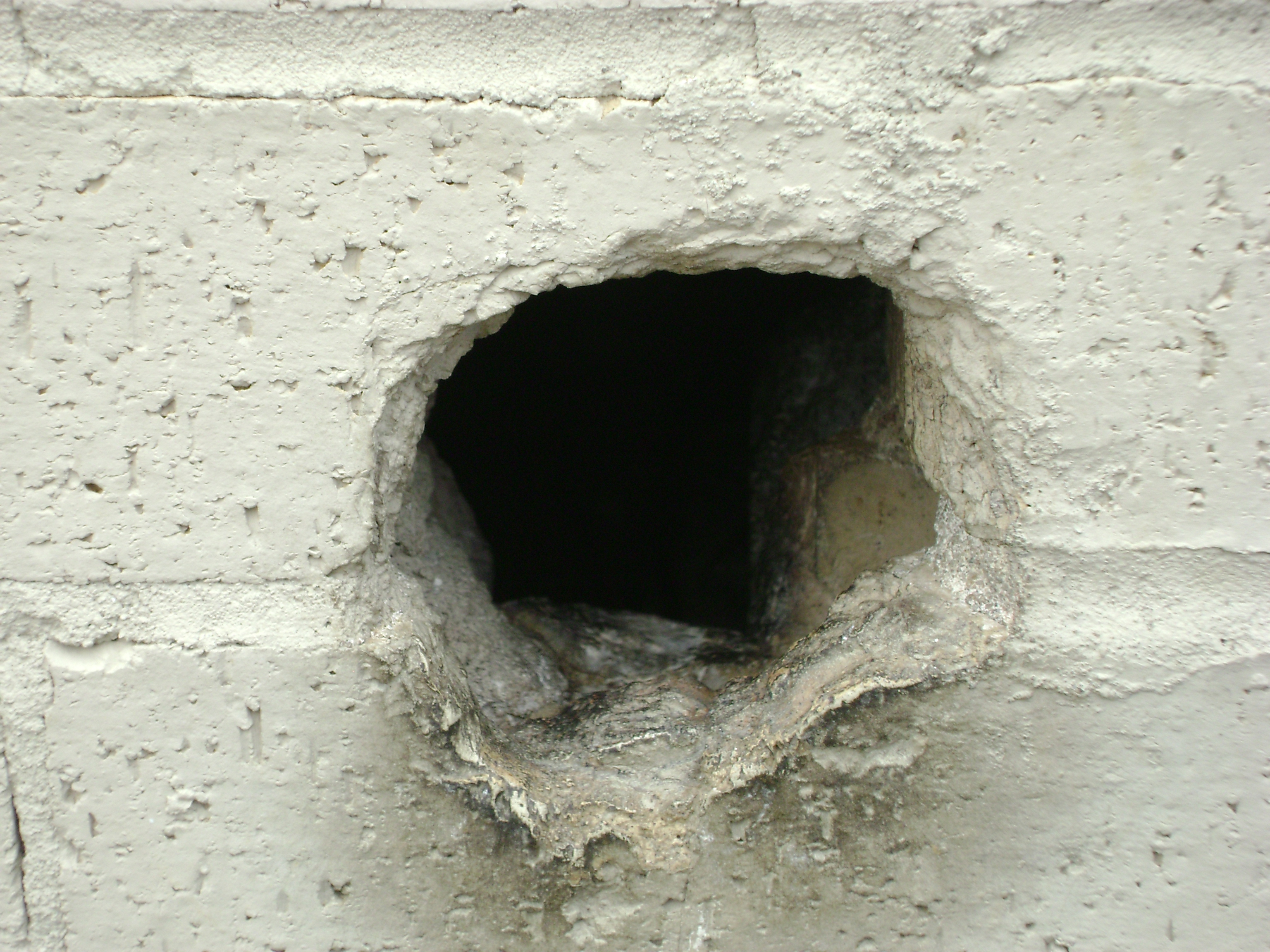 В стене дыра в дыре глаза. Дырка в стене. Пробоина в стене. Отверстие в бетонной стене.