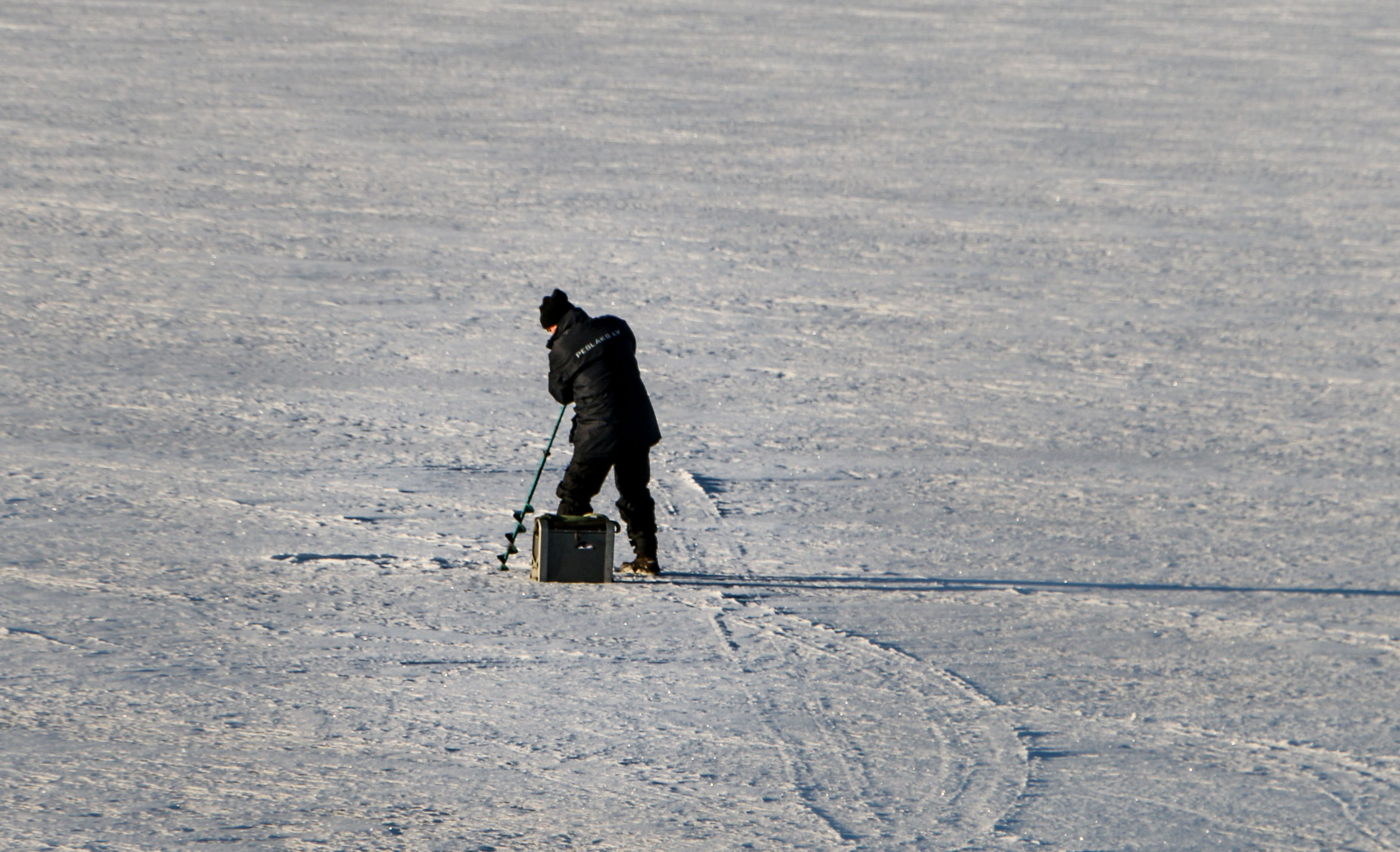 Ice fisherman with a drill photo