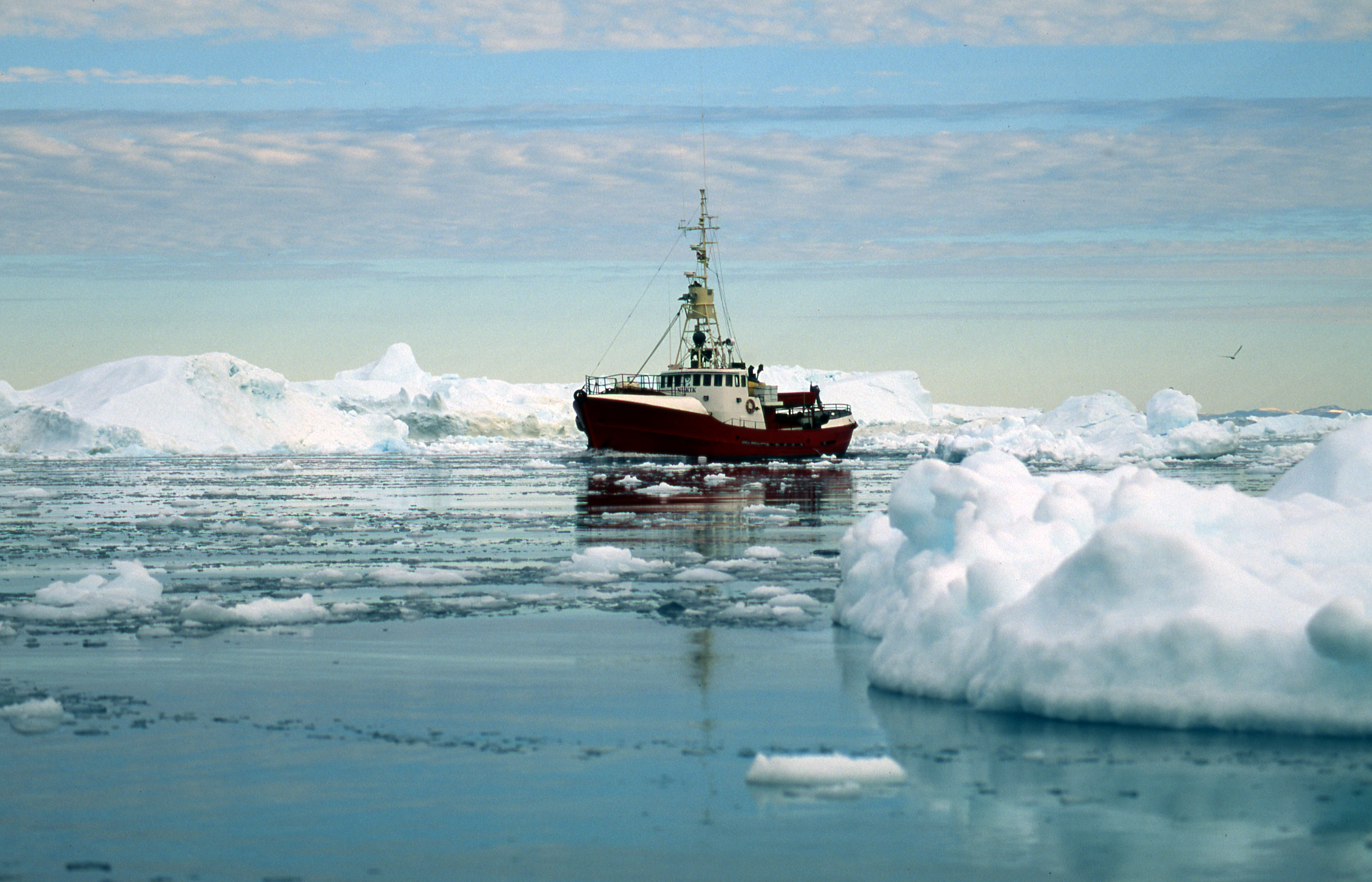 Fishing boat in between icebergs, Disco Bay, Greenland | GRID-Arendal