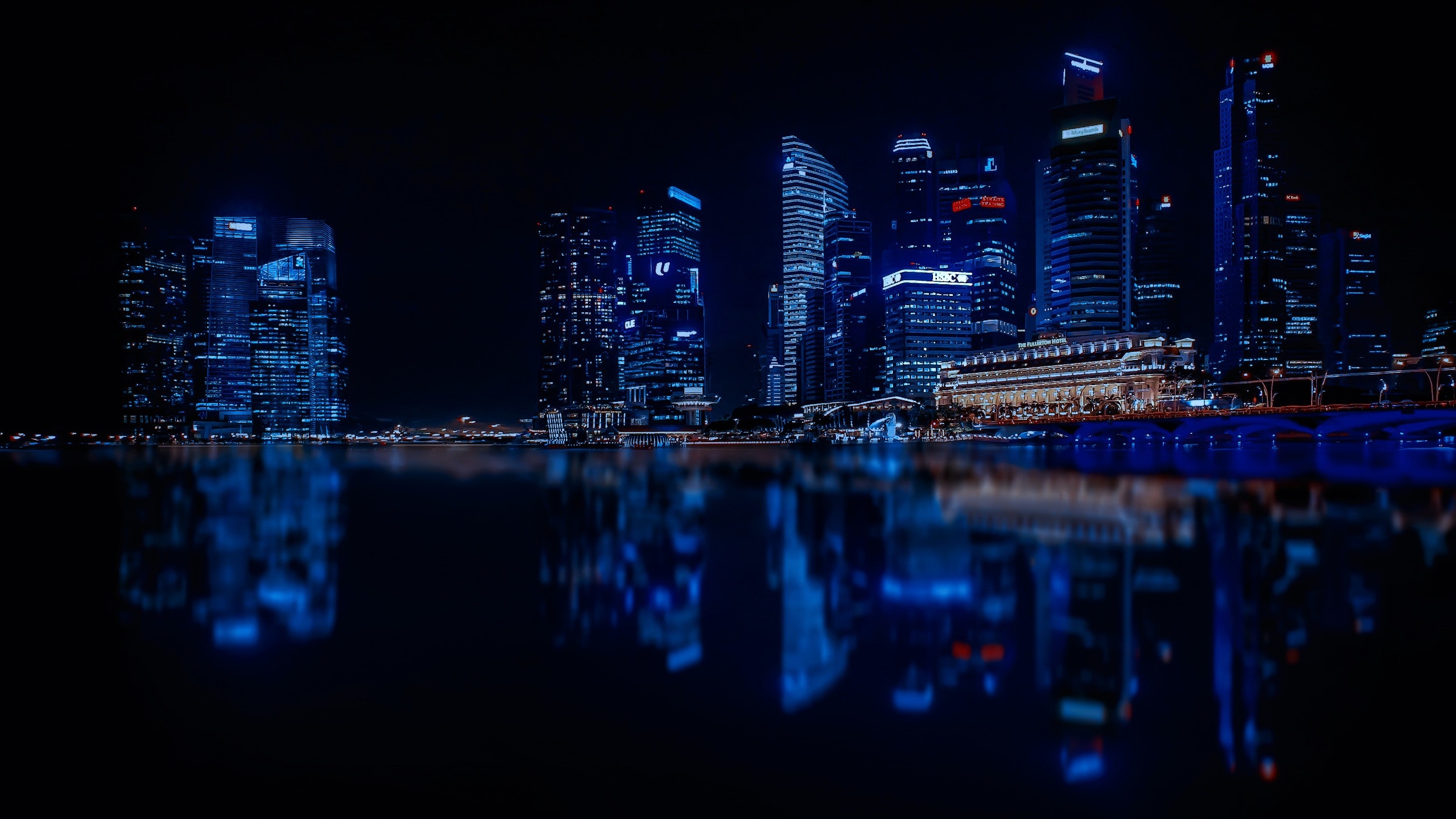 Illuminated cityscape against blue sky at night photo