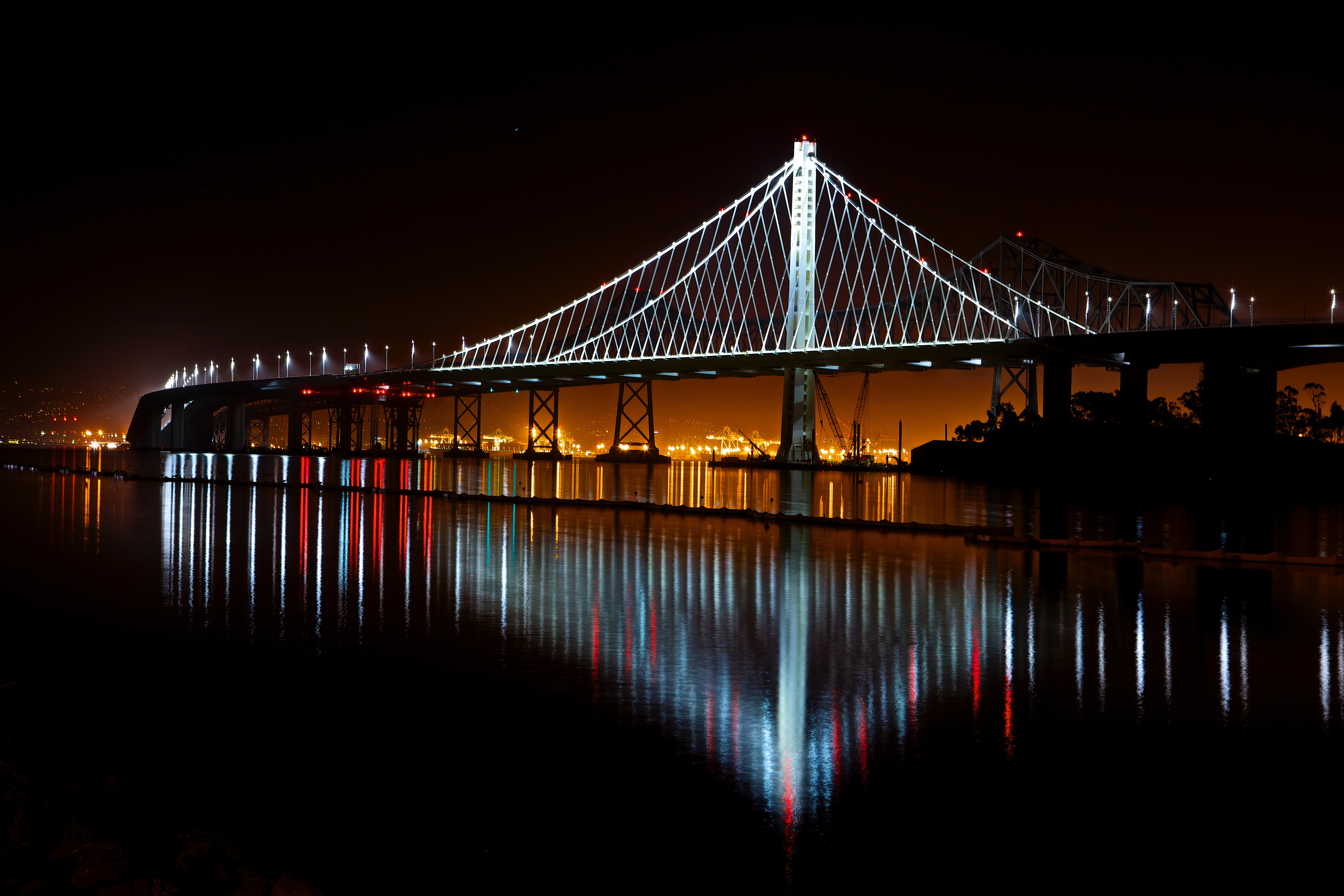 Illuminated suspension bridge against sky at night photo