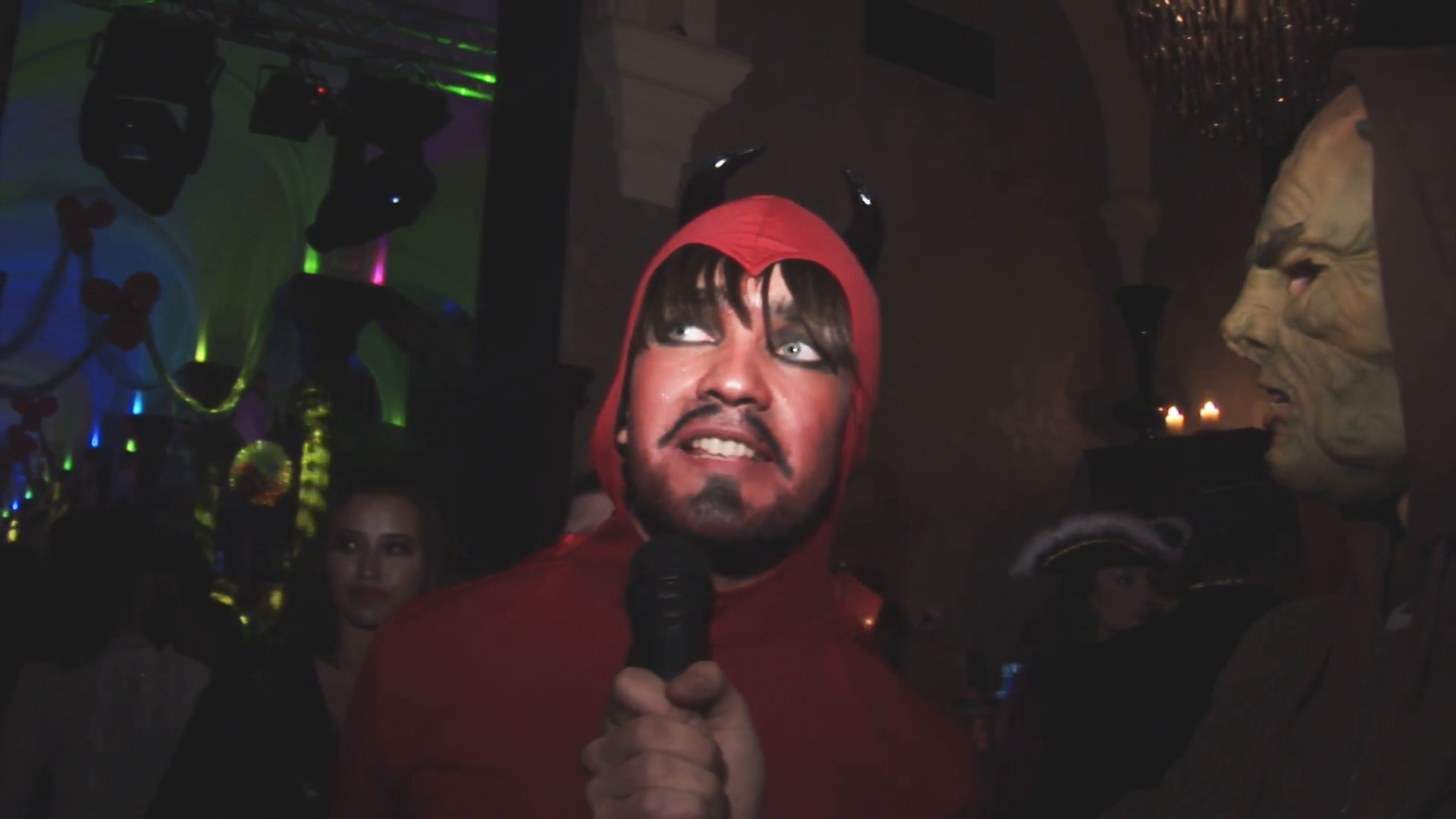 Man in devil red costume give interview on Halloween party in ...