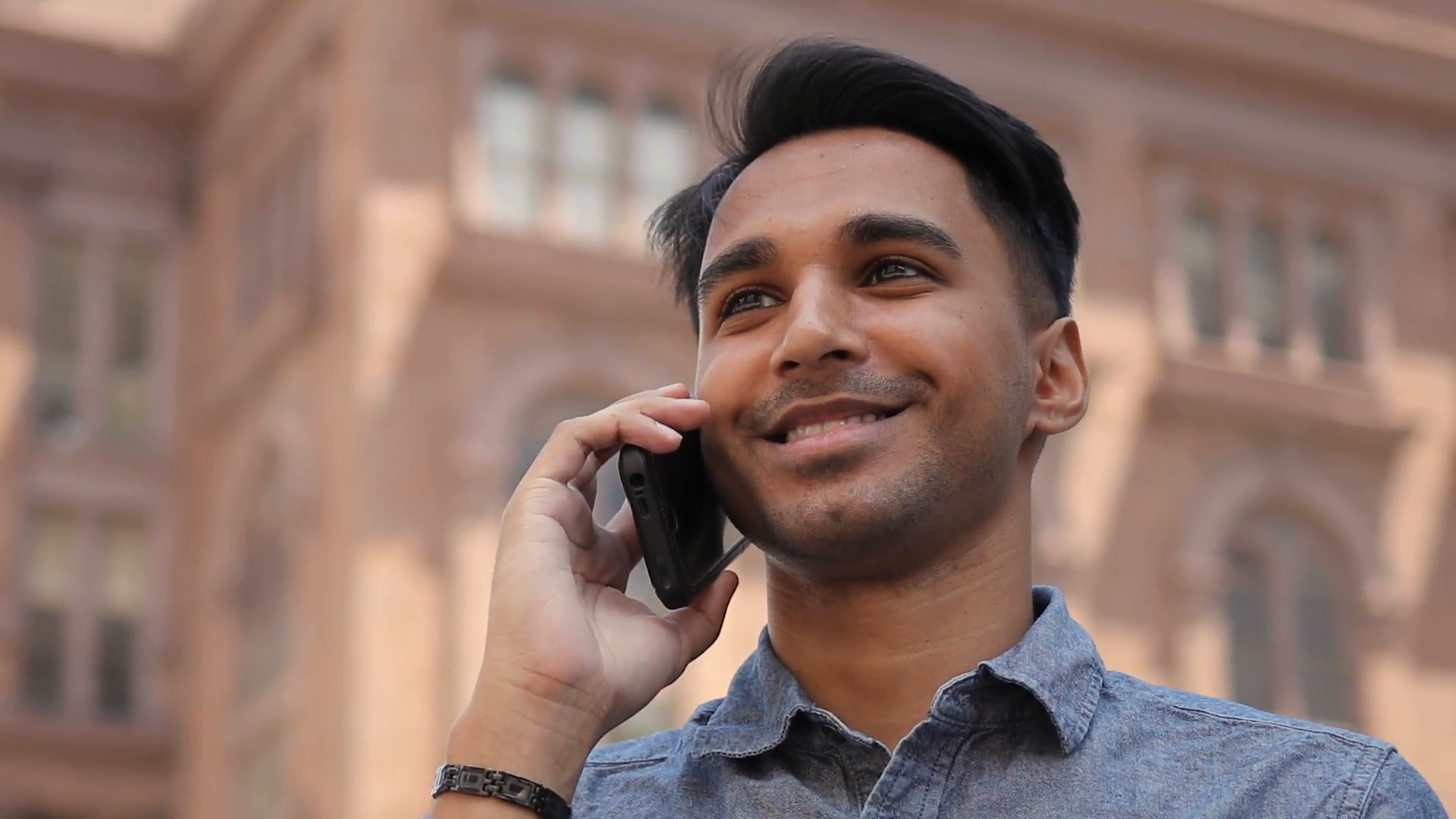 Young Indian man in city talking on cell phone Stock Video Footage. 
