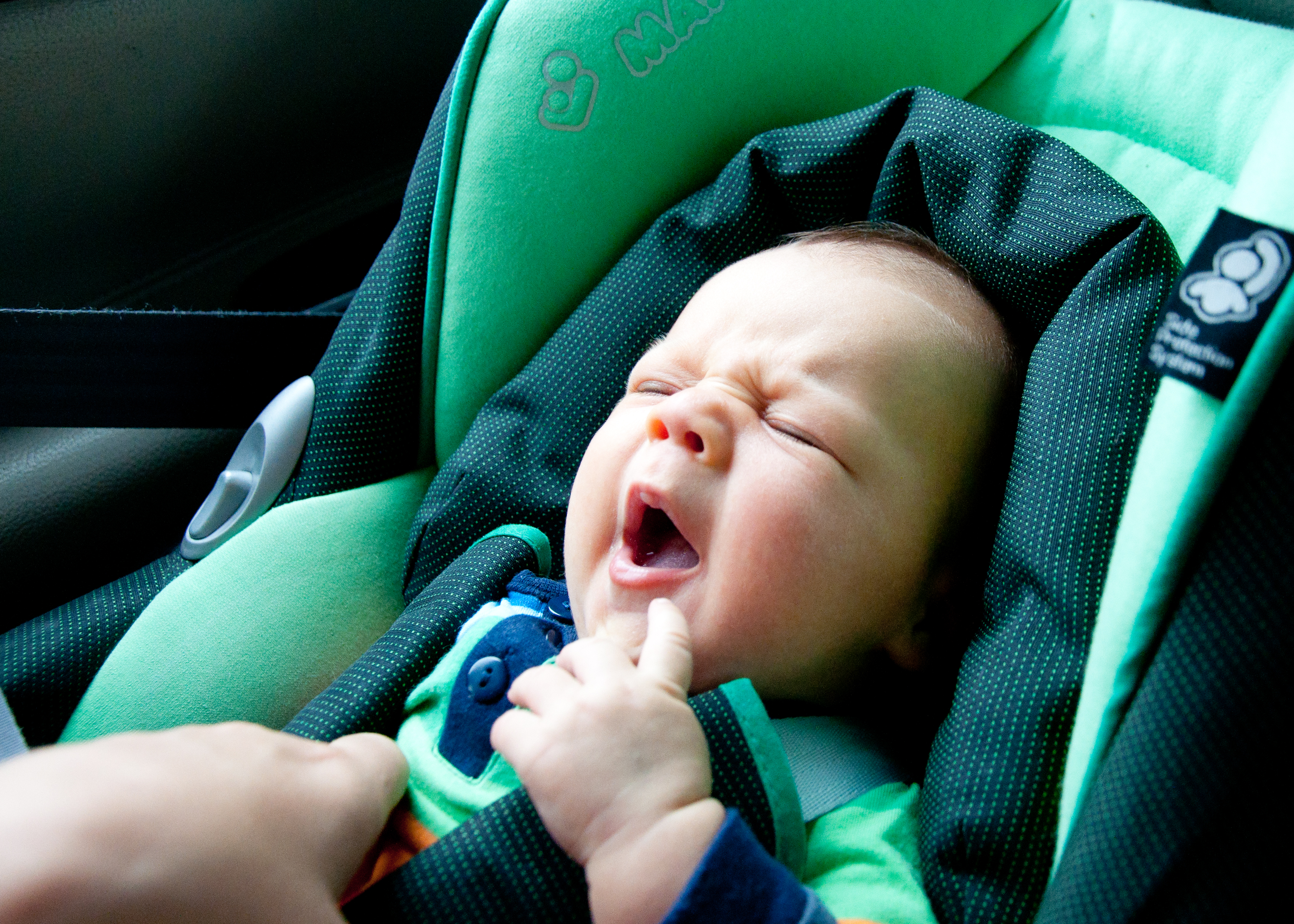 Infant child sitting in car seat photo