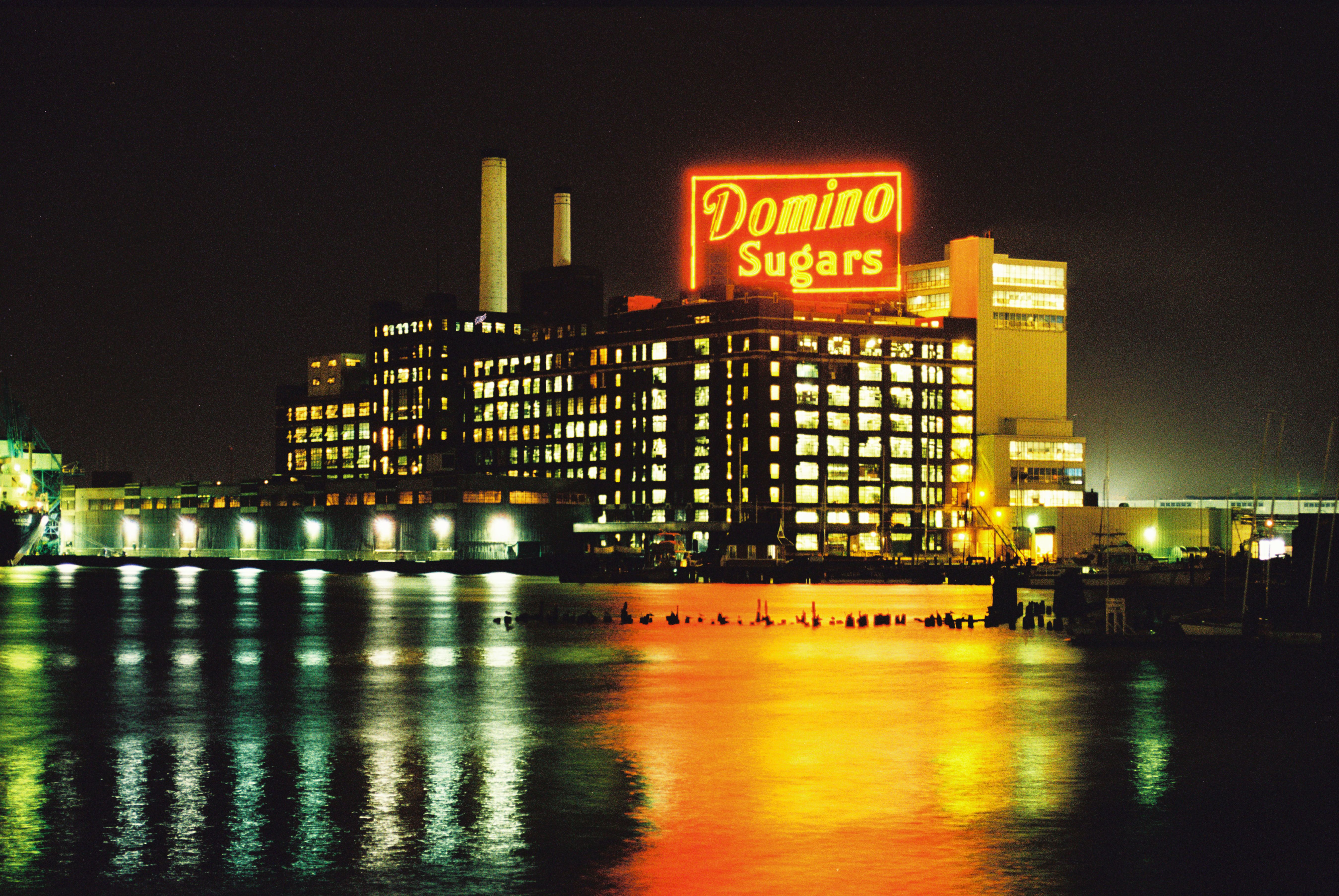 The iconic Domino Sugars sign shines brightly from across the Inner ...