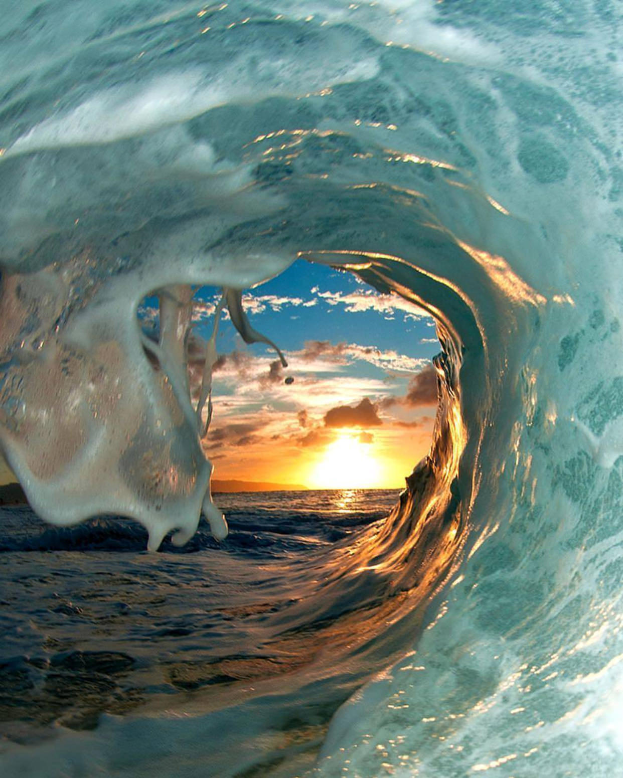 A view of the sunrise from inside a wave is 
