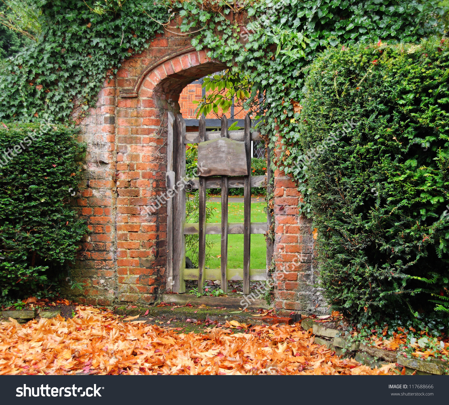 Rustic Ivy Covered Arched Gateway And Red Brick Wall Into An Save To ...