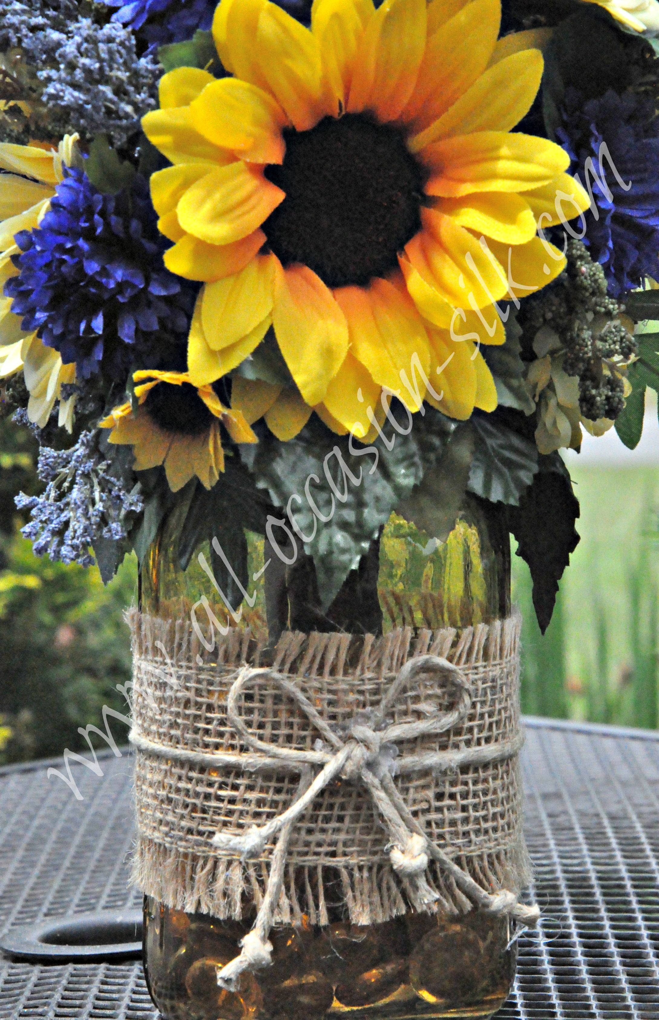 Rustic-style centerpiece featuring sunflowers, blue delphinium, blue ...
