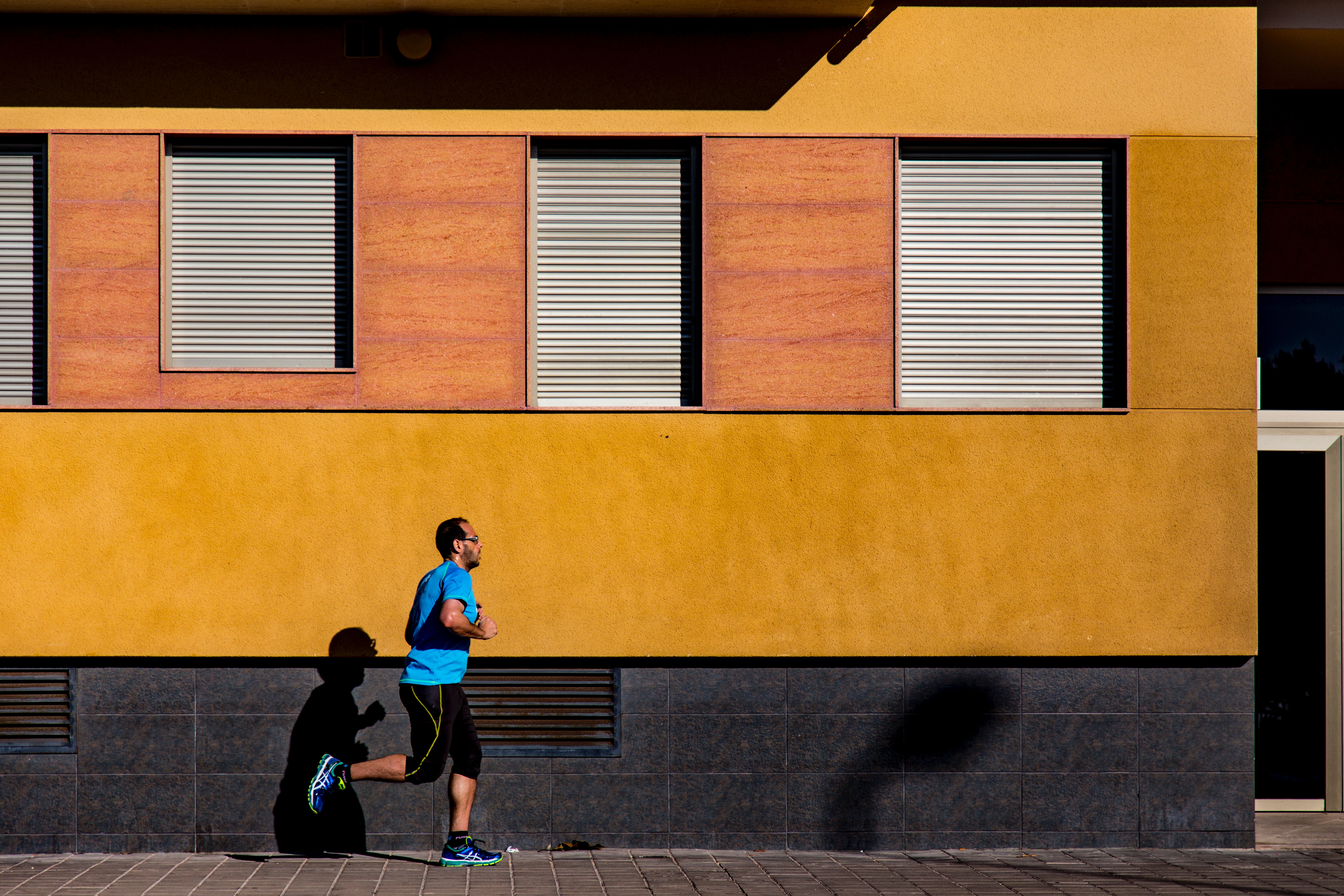 Jogging man wearing blue shirt during daytime photo