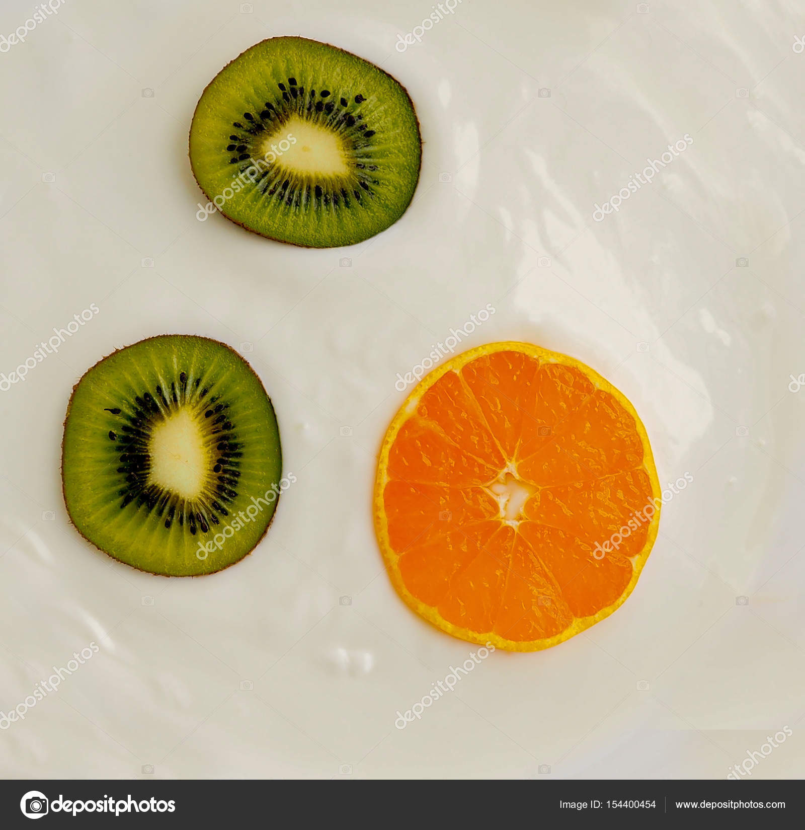 orange tangerine and kiwi closeup of white cream with a texture as a ...
