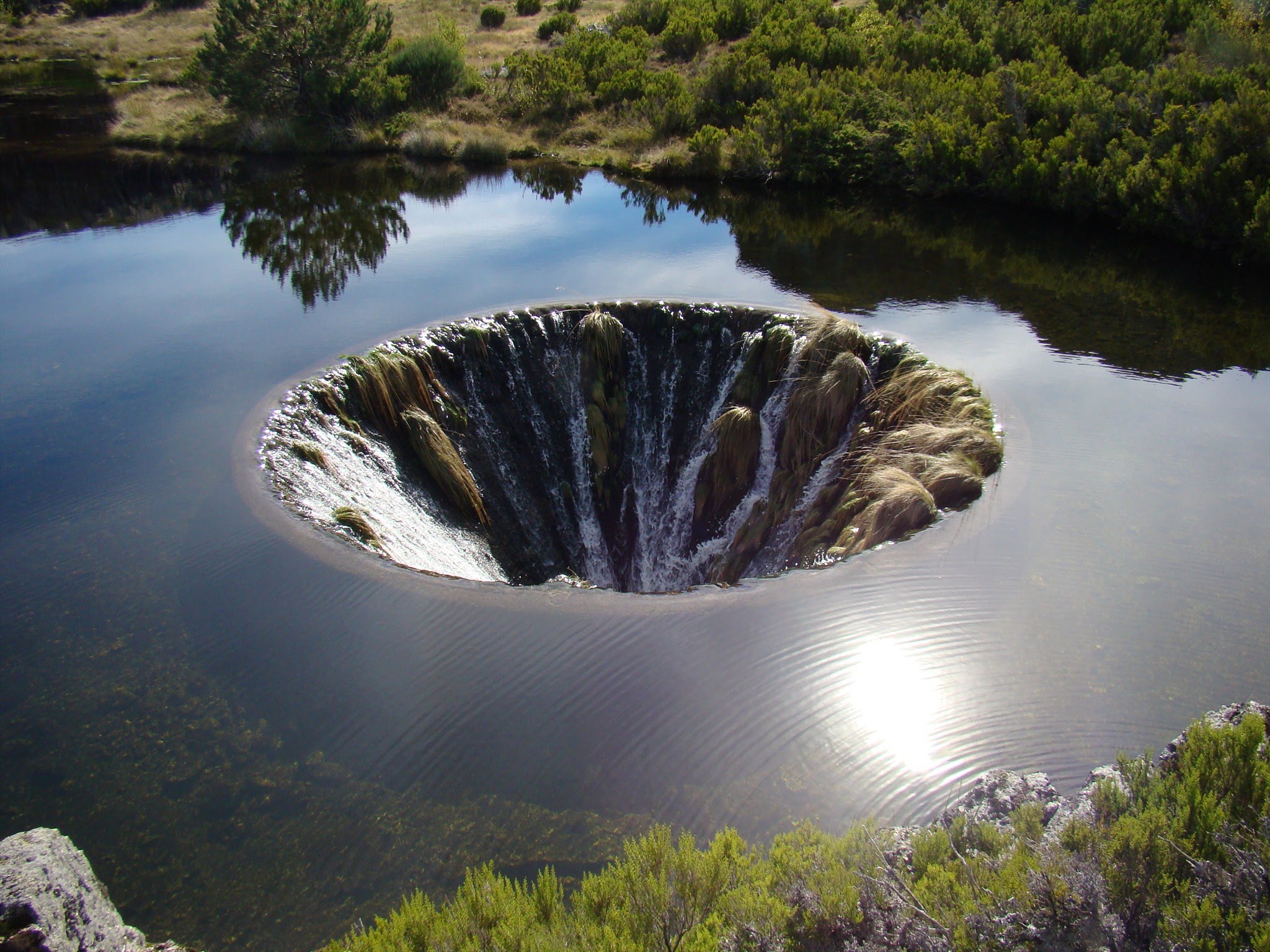 Уникальные творения природы. Озеро Кончос. "Дырявое озеро" Кончос. Водохранилище Кончос в Португалии. Карстовая дыра, гора Серра-да-Эштрела.