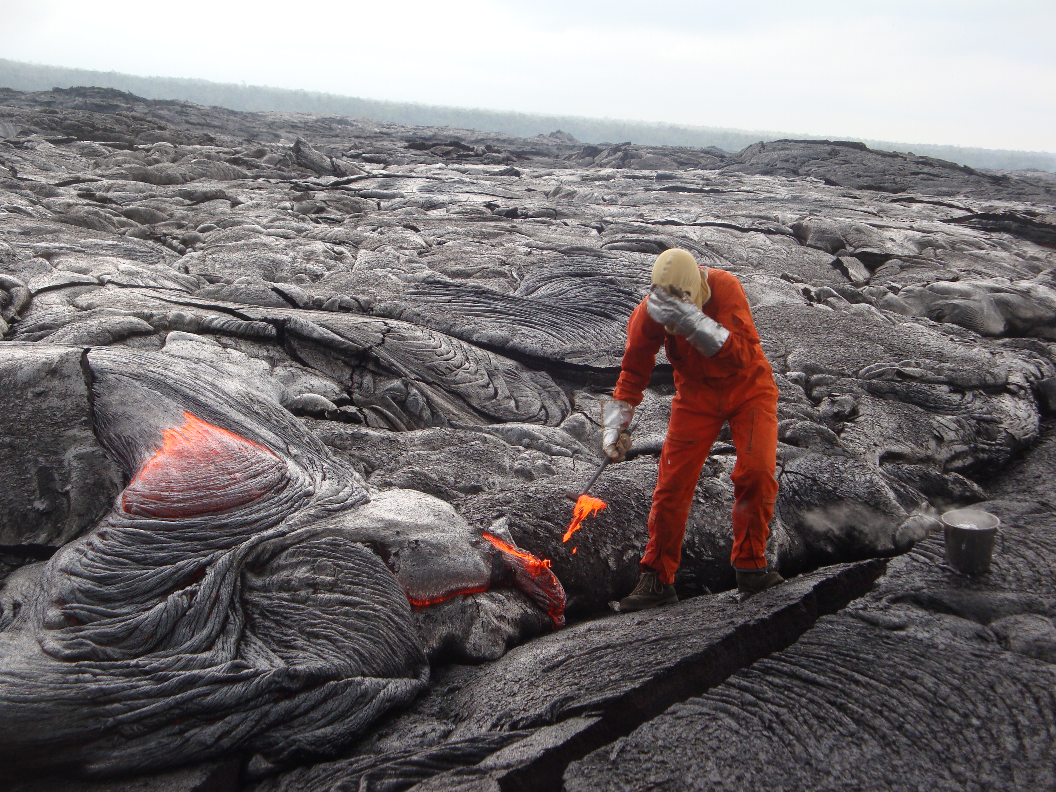 HVO geologist shields face from intense lava-flow heat while taking ...