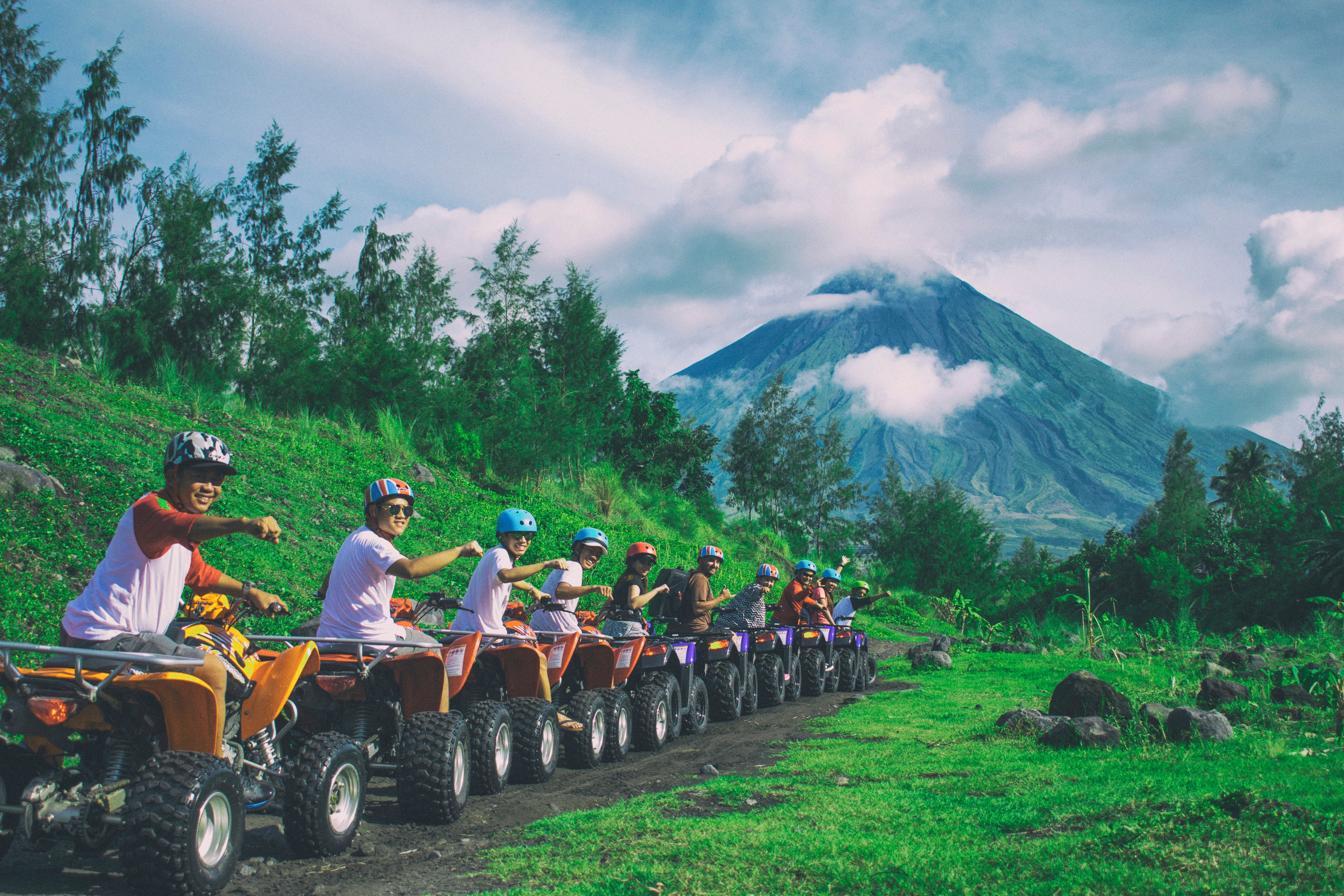 Line of men riding on all terrain vehicles holding out hand in a fist photo