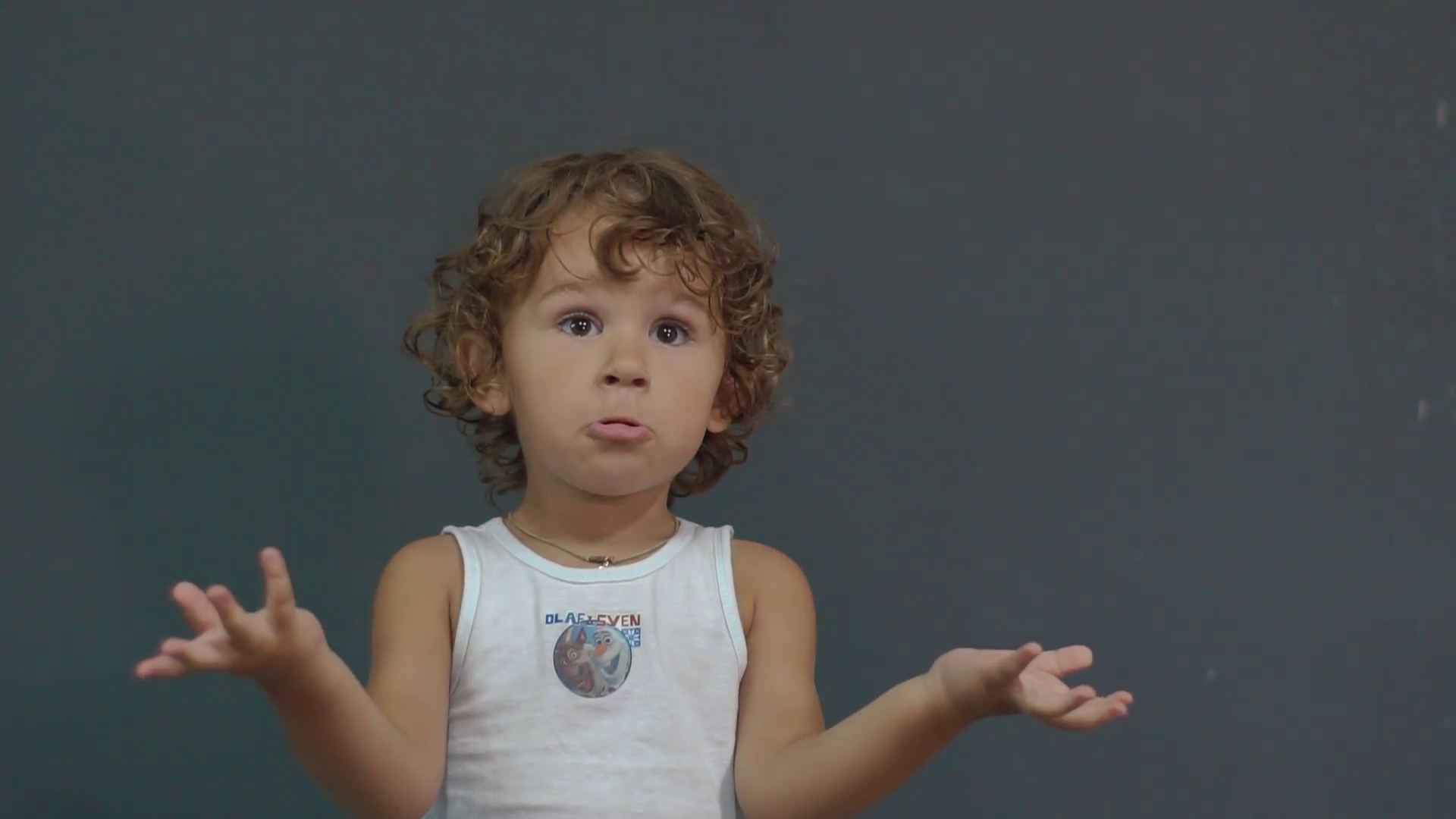 Confused little boy in white shirt gesture over grey background ...