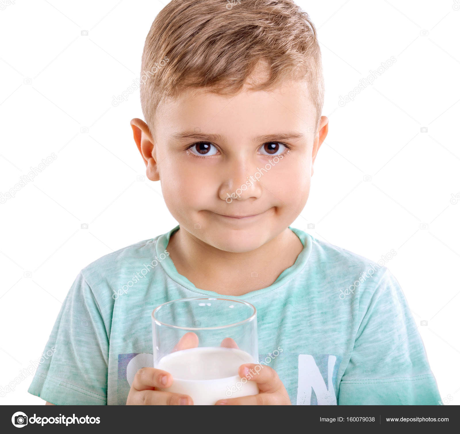 Adorable little boy in blue T-shirt with a glass full of fresh milk ...