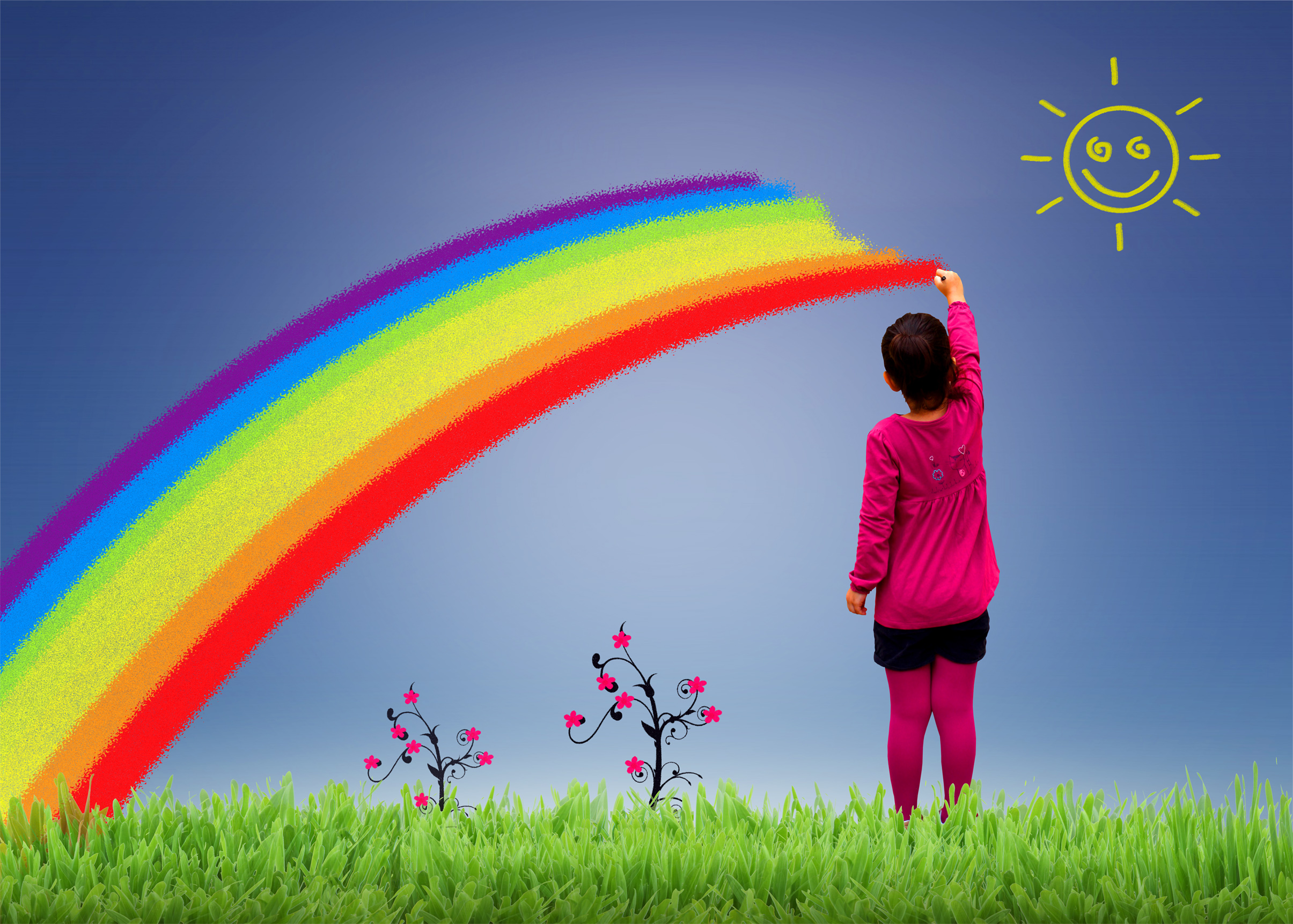 Little girl painting a rainbow on the sky photo
