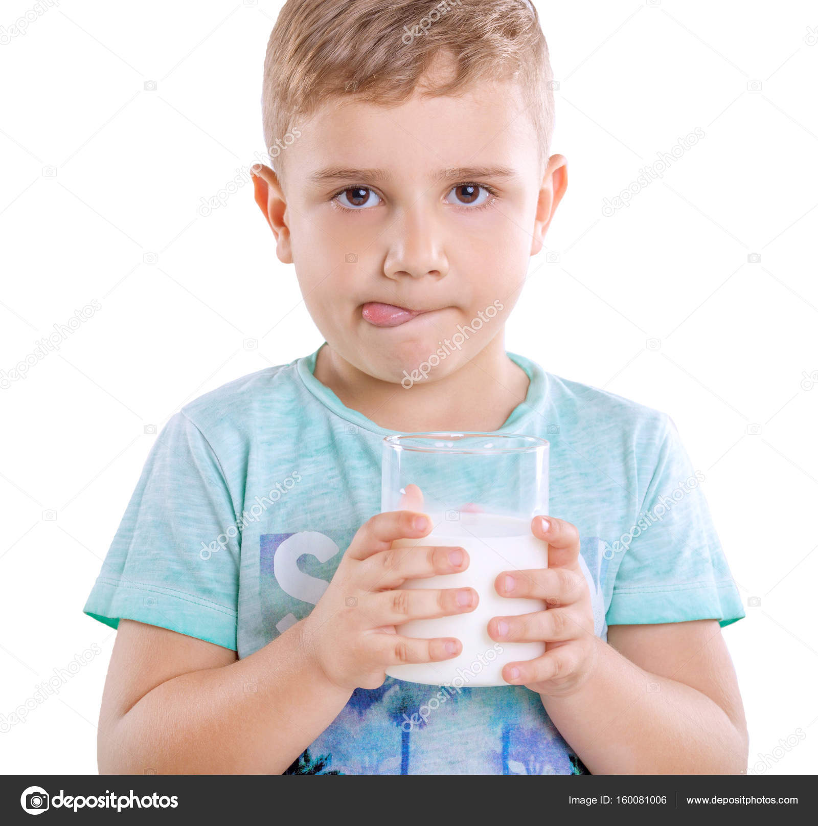 Cute little boy with blonde hair in blue T-shirt is holding a glass ...