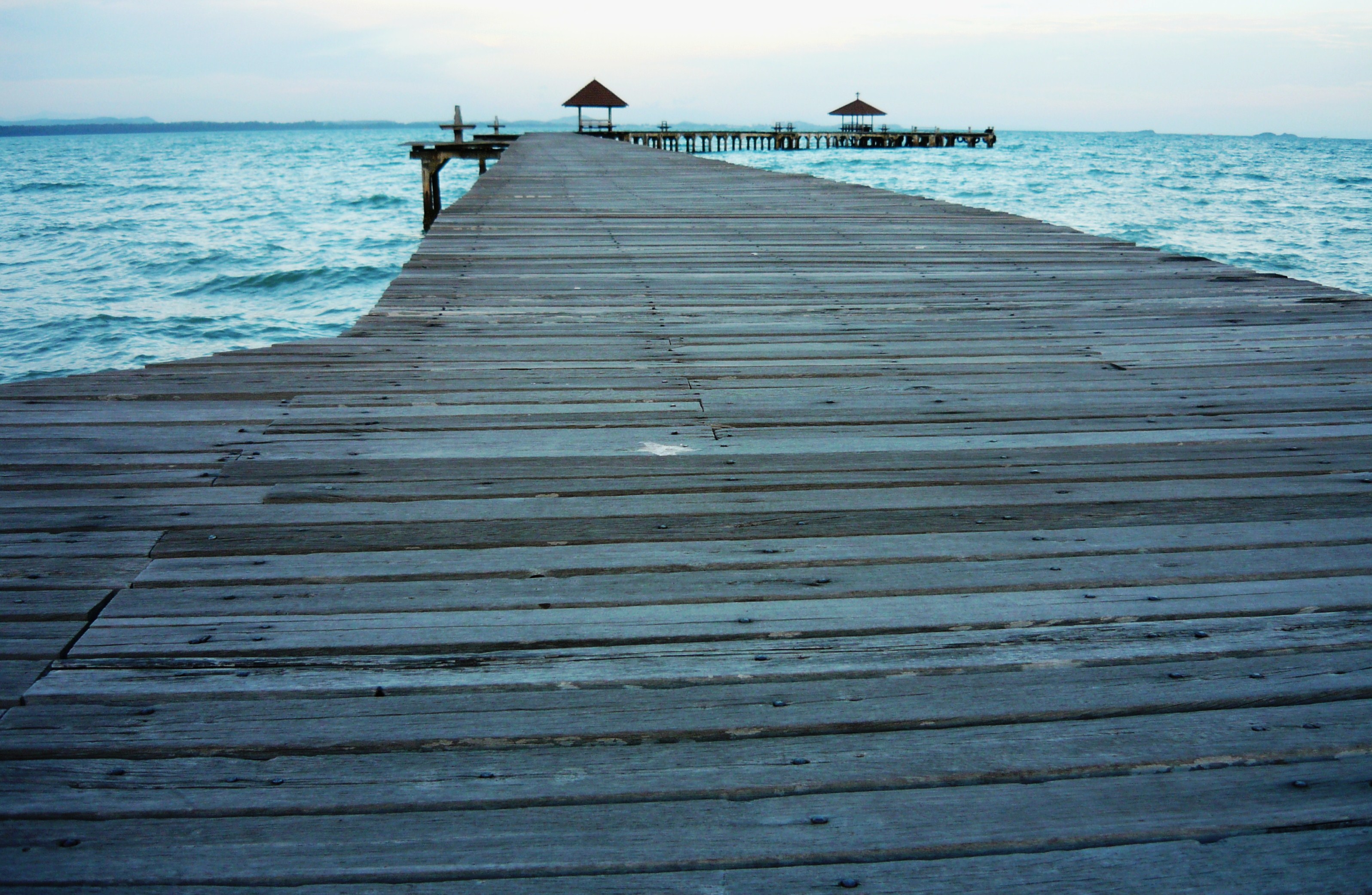 Long wooden tropical pier at sunset photo