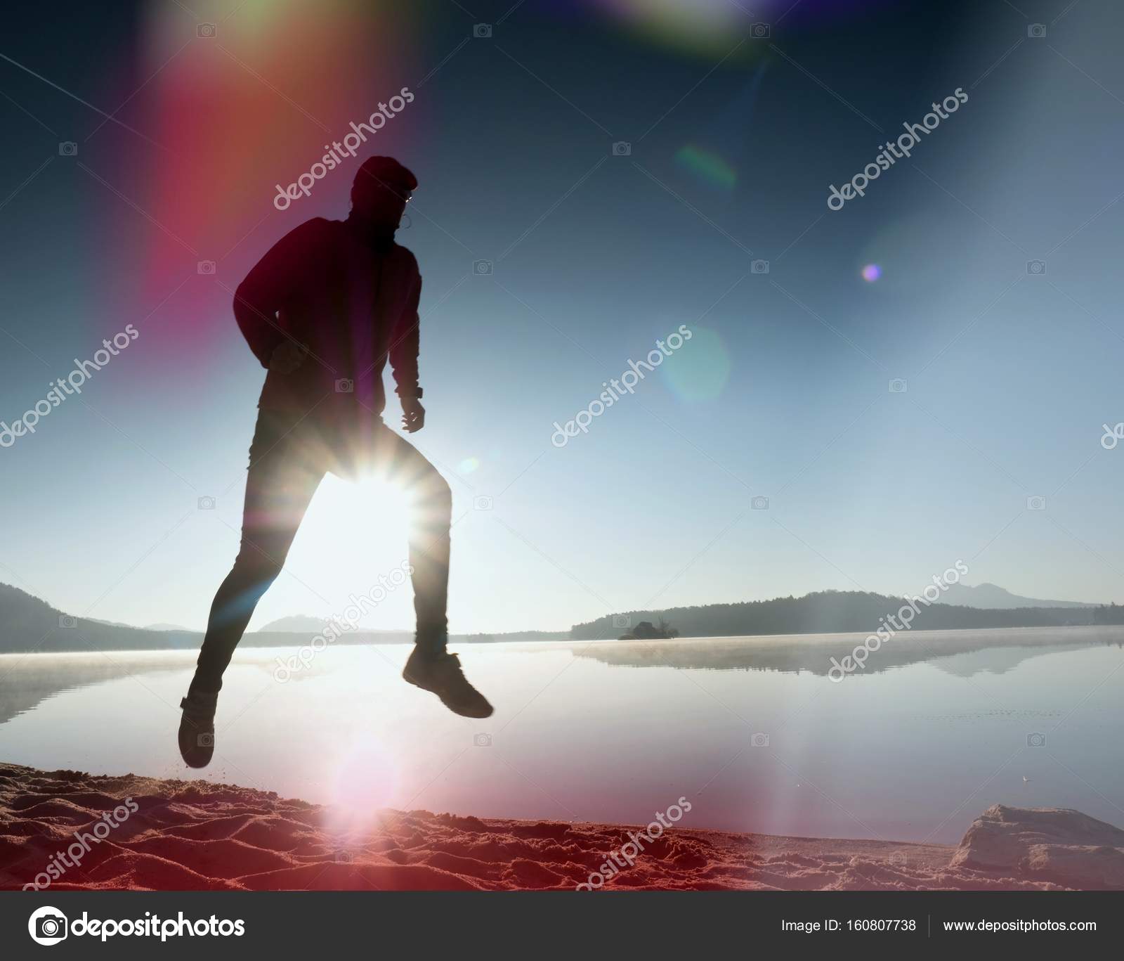 Leakage of light in the lens. Exercising man silhouette on beach ...