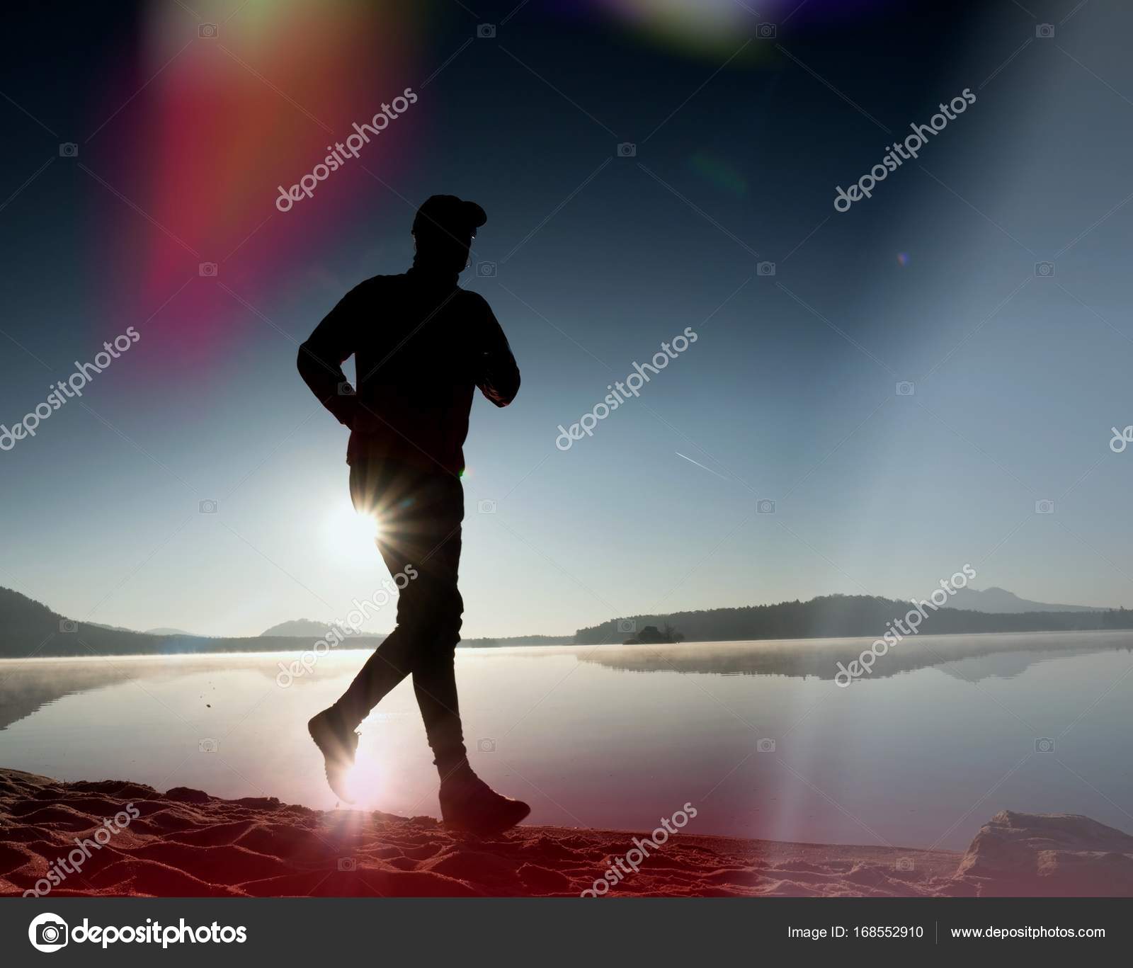 Leakage of light in the lens. Exercising man silhouette against to ...