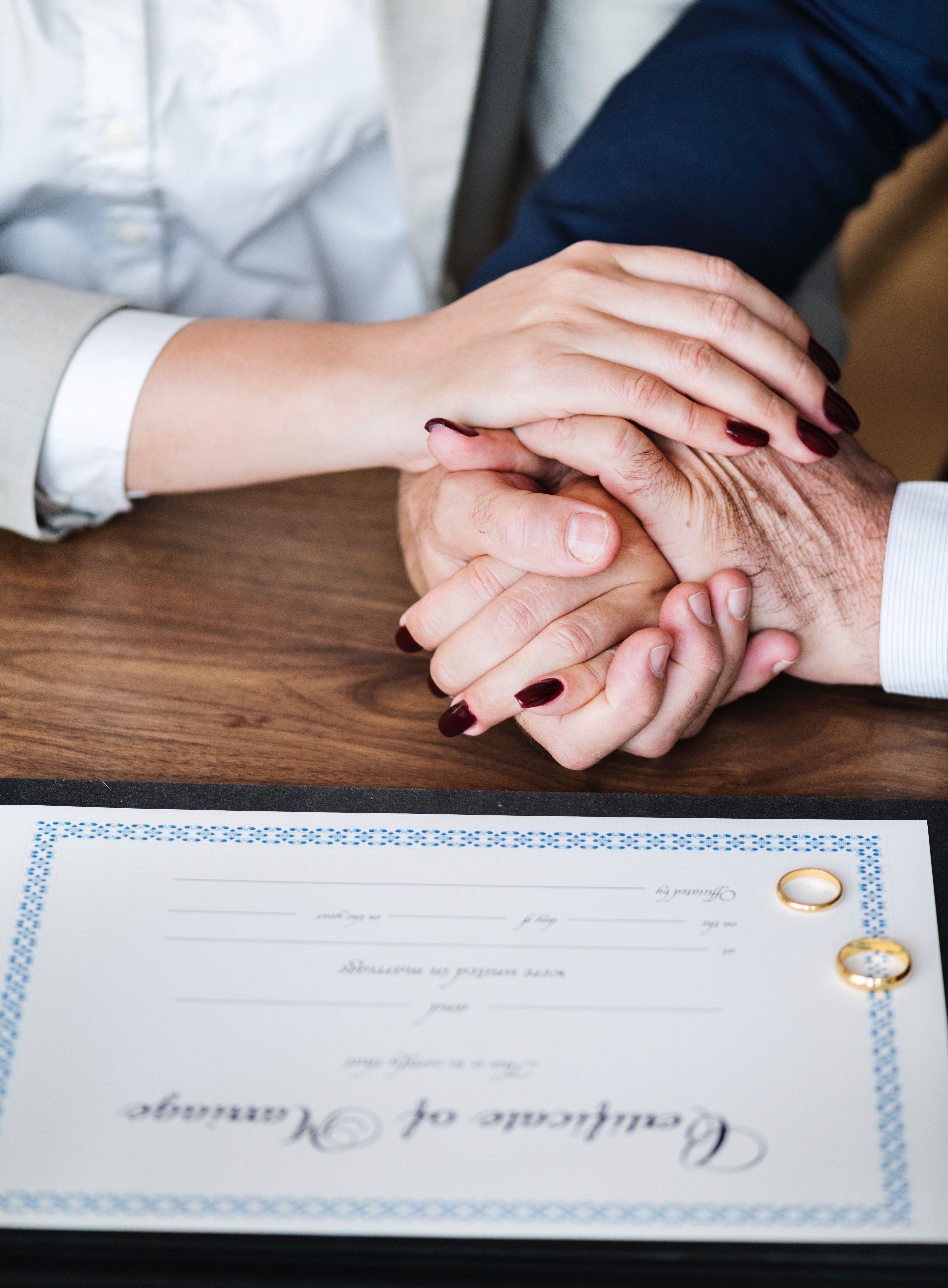 Man and Woman Holding Hands on Brown Wooden Table, Adults, Marriage Certificate, Wife, Wedding rings, HQ Photo