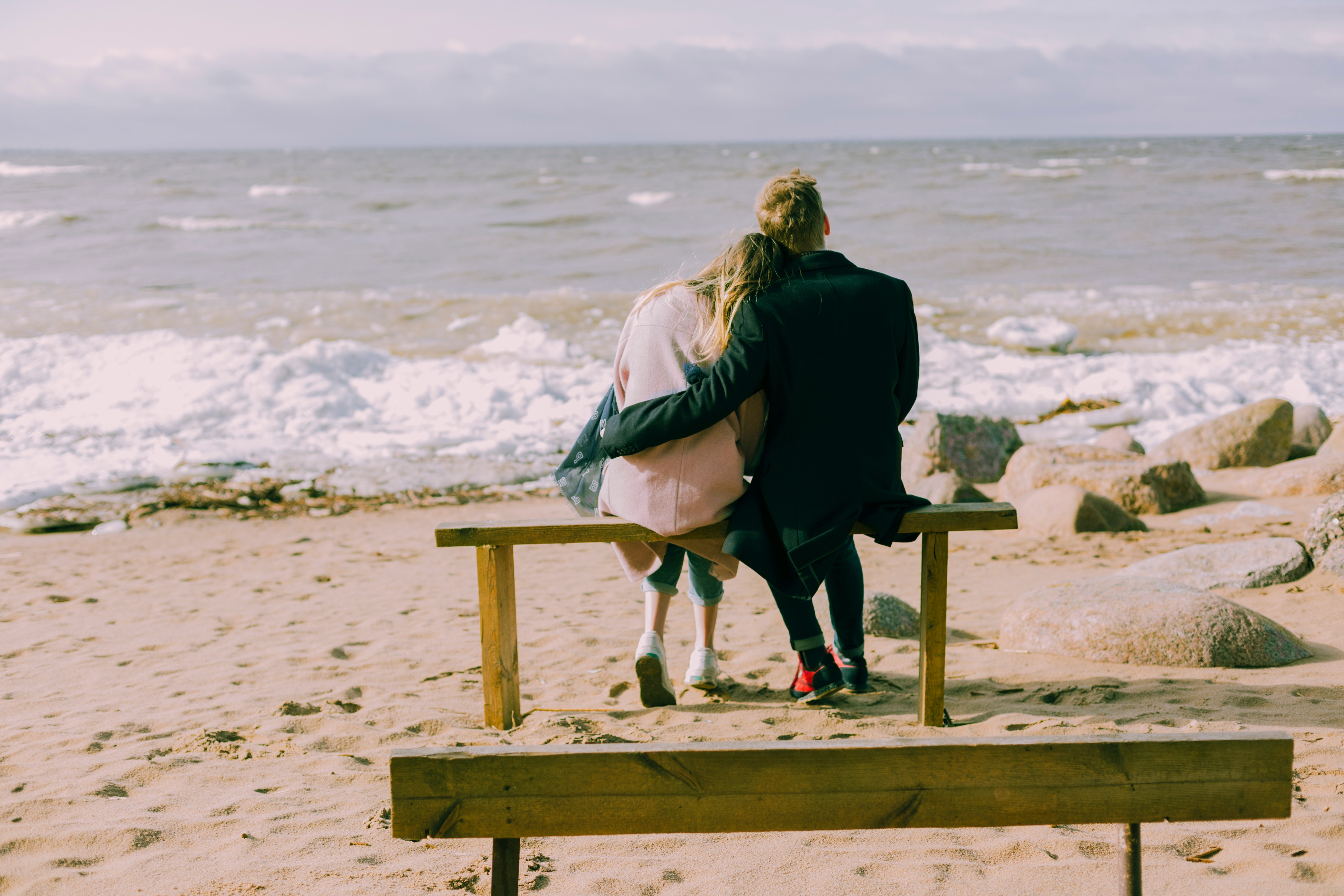 Man and woman hugging and sitting on a bench photo