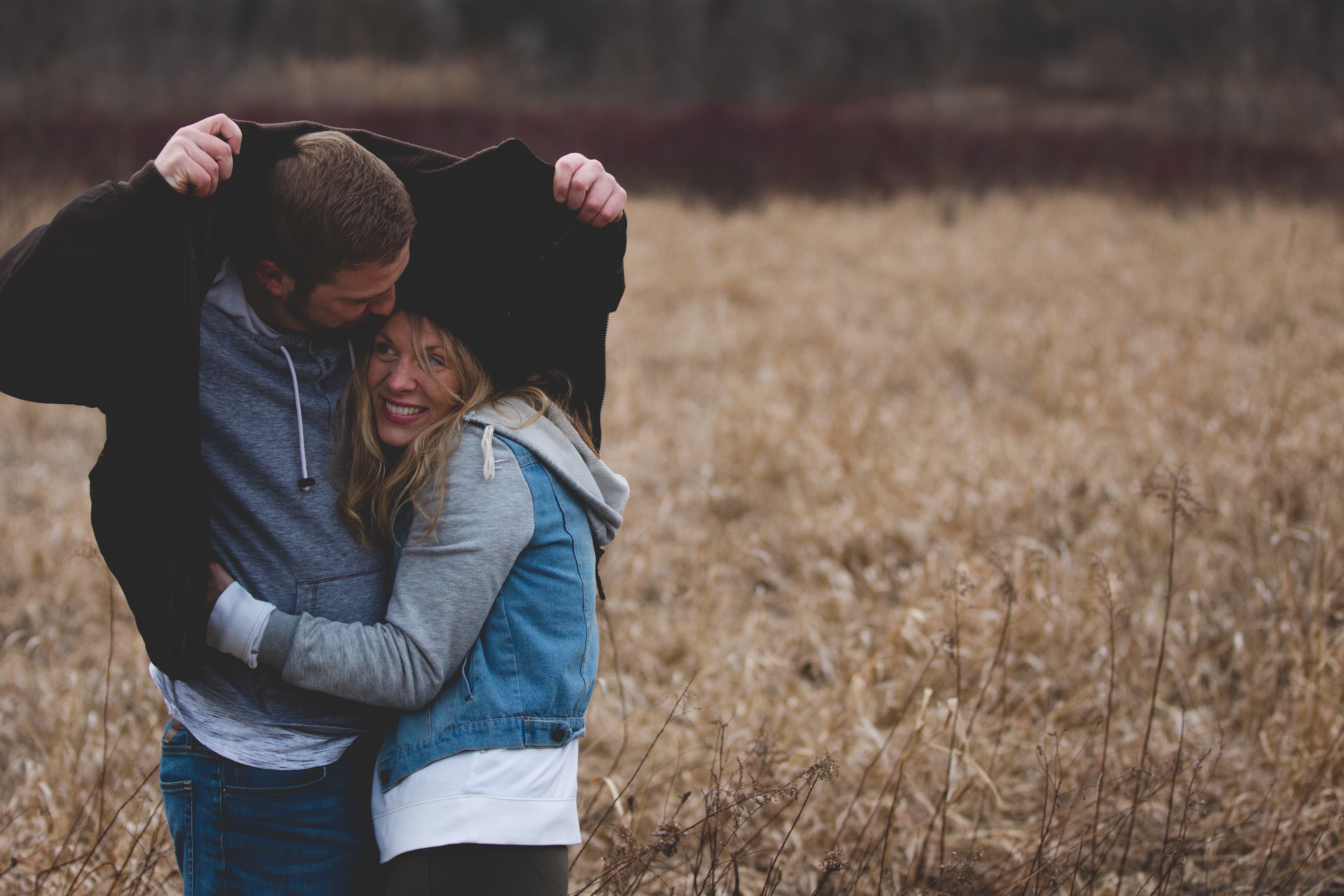 Man and woman hugging on brown field photo
