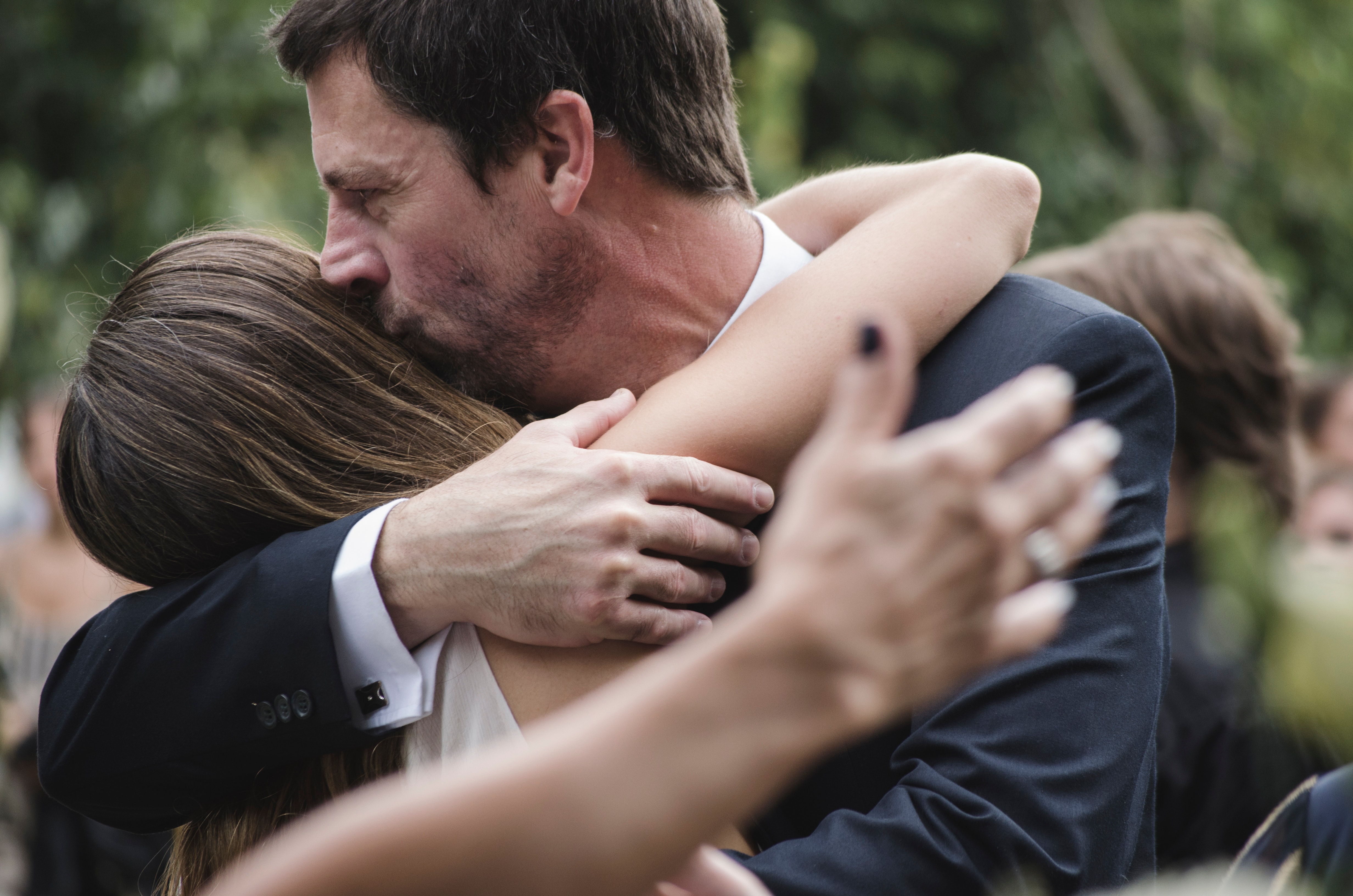 Man and woman hugging while man kissing woman's head photo