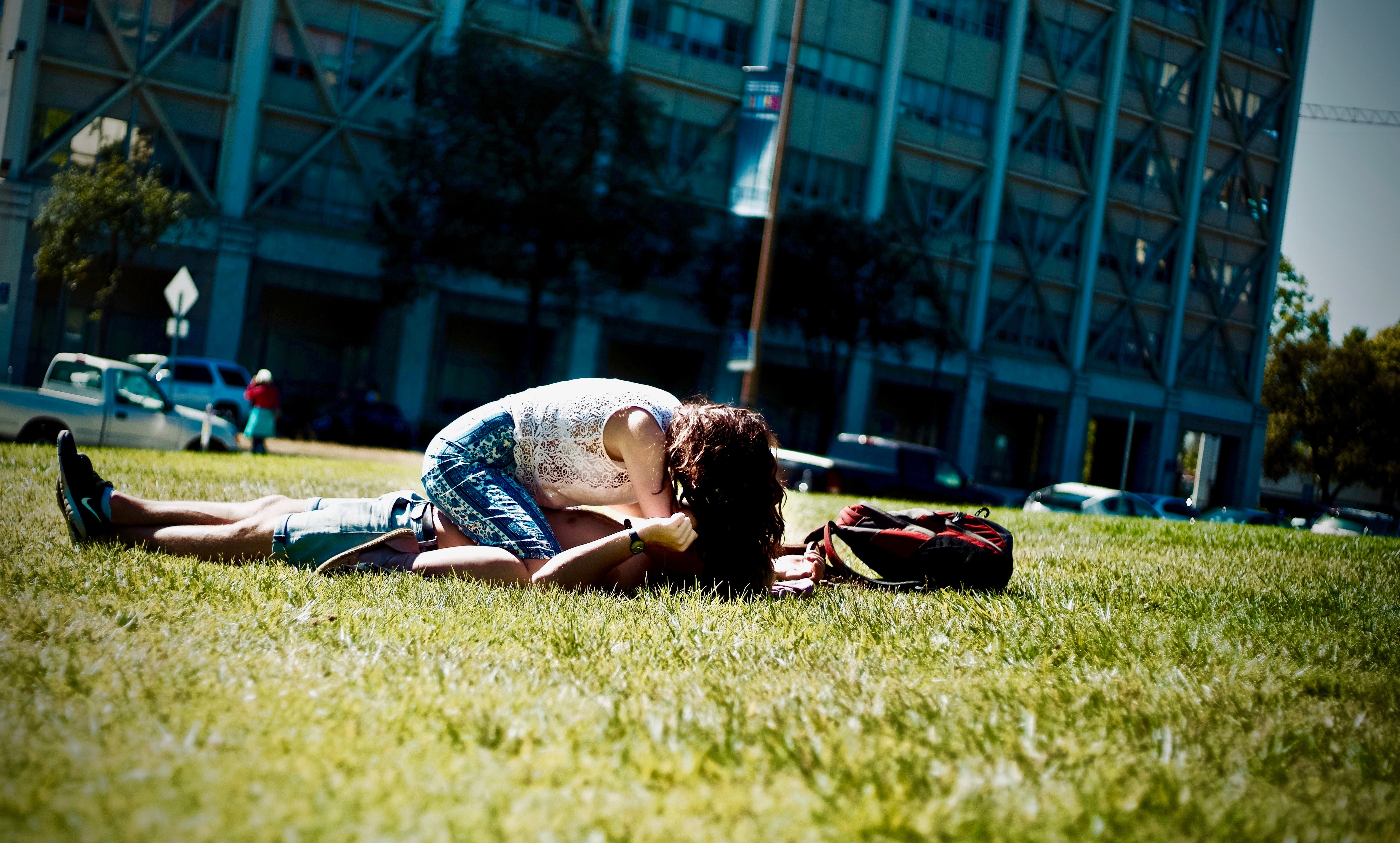 Man and woman lying on green field photo