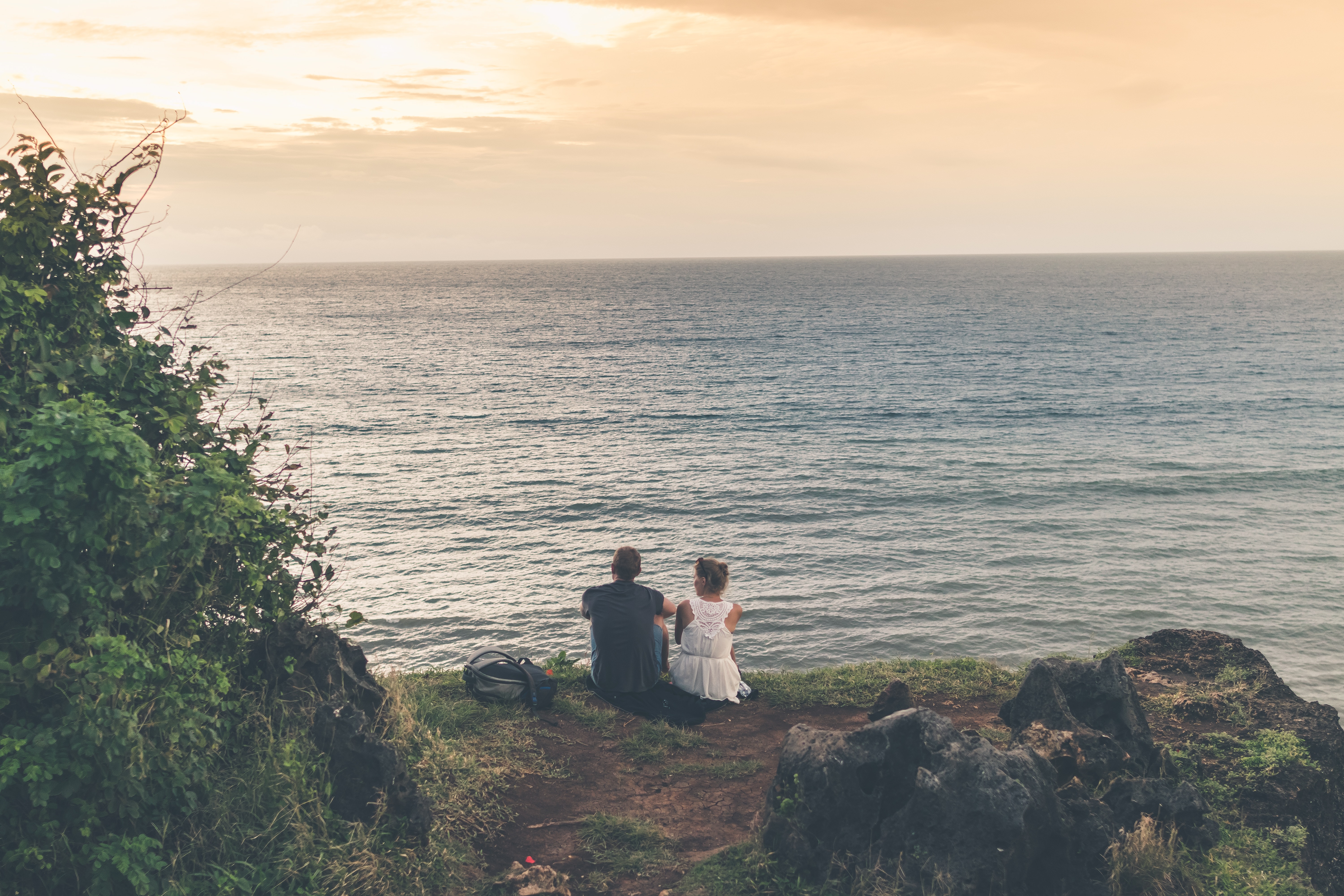 Man and woman sitting near body of water photo