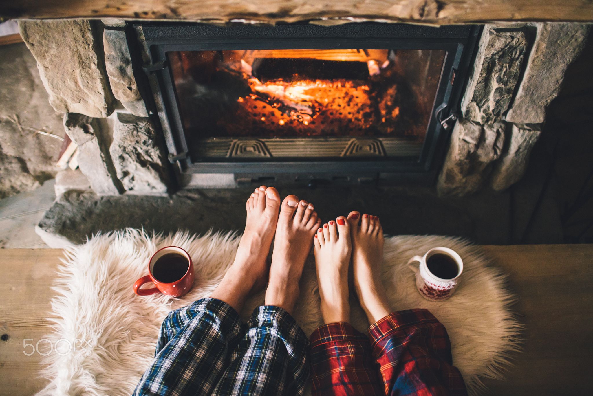 Bare couple feet by the cozy fireplace. Man and Woman relaxes by ...