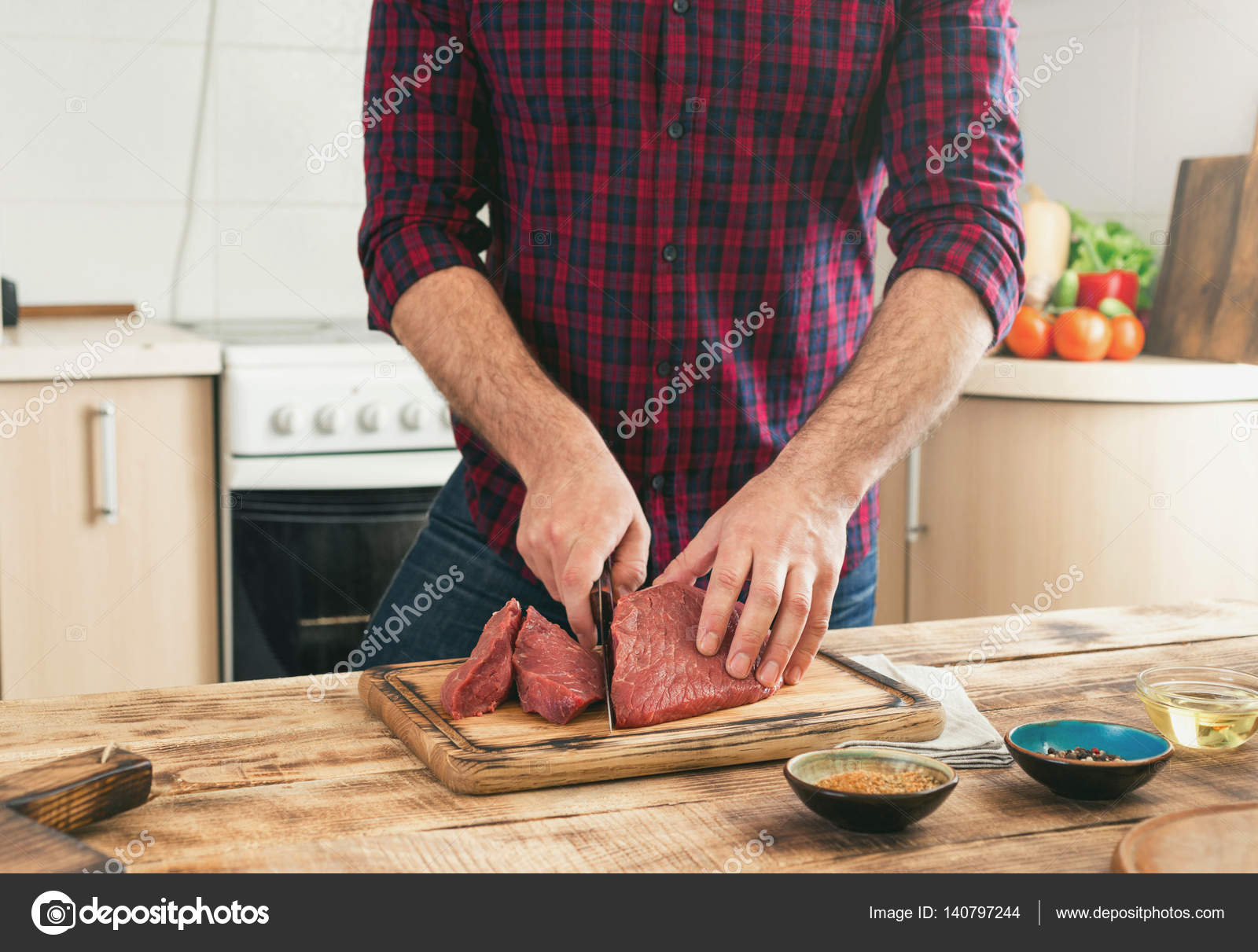 Man cooking beef meat on wooden table in the kitchen — Stock Photo ...