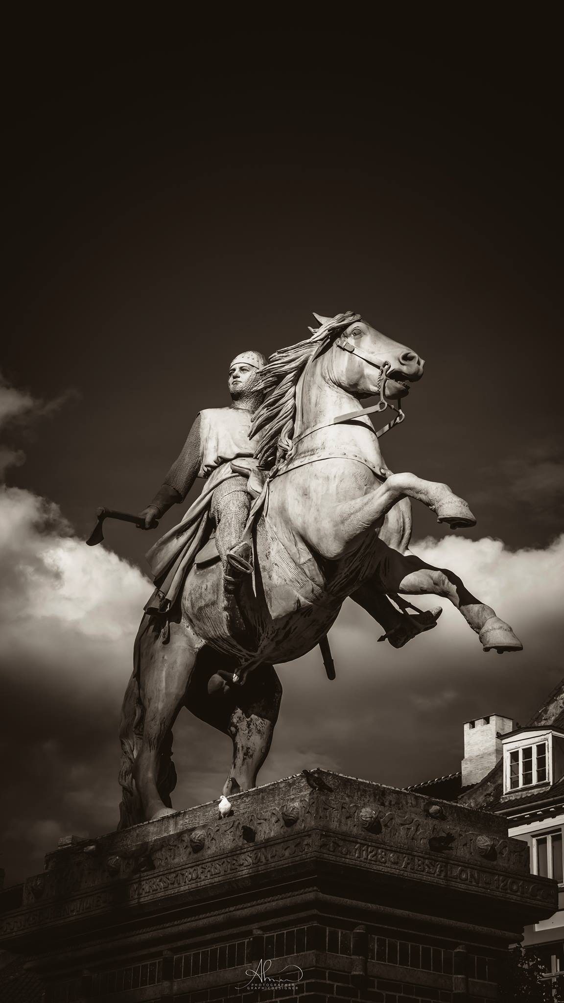 Man holding axe rides on horse concrete statue photo