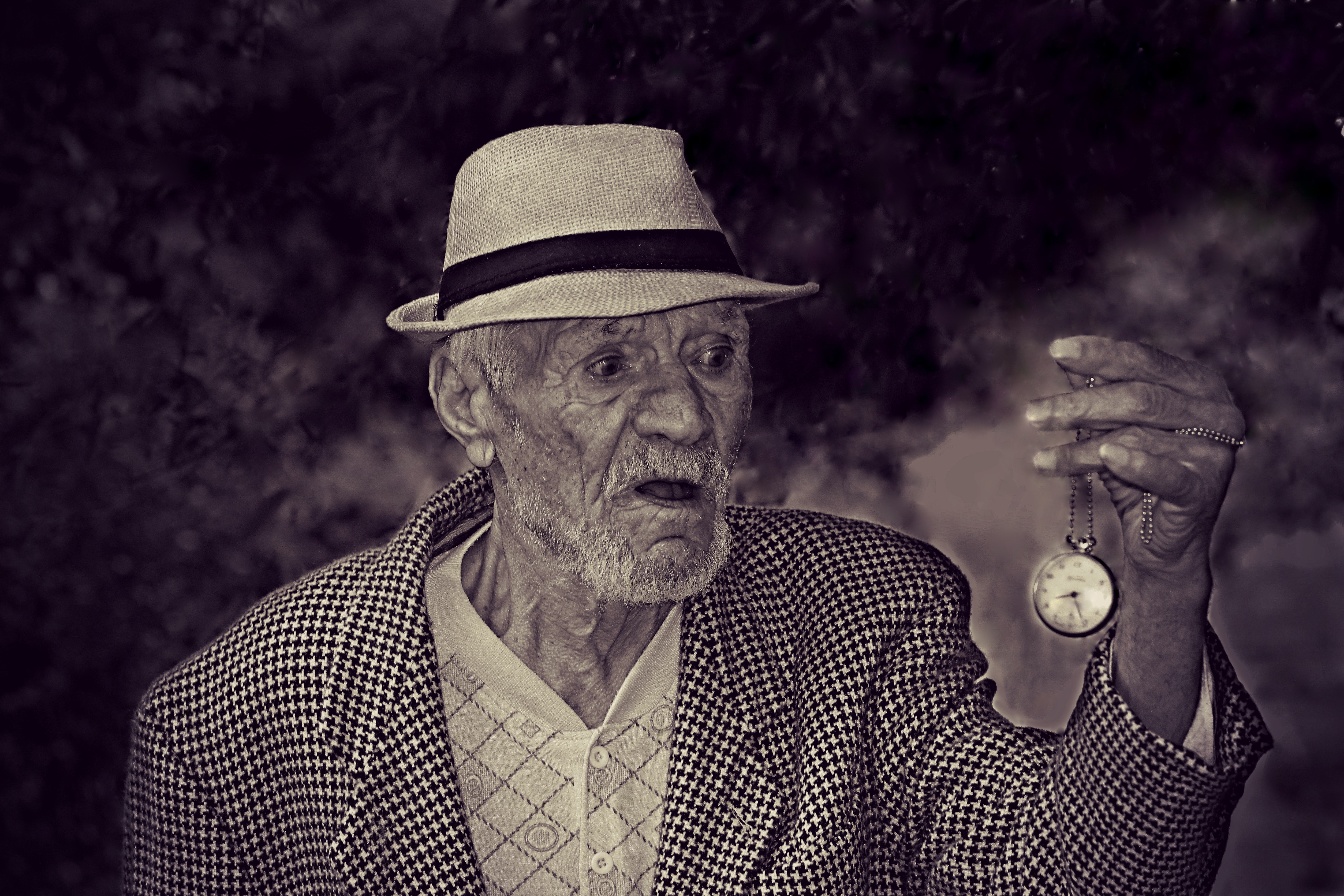 Man holding pocket watch in grayscale photo