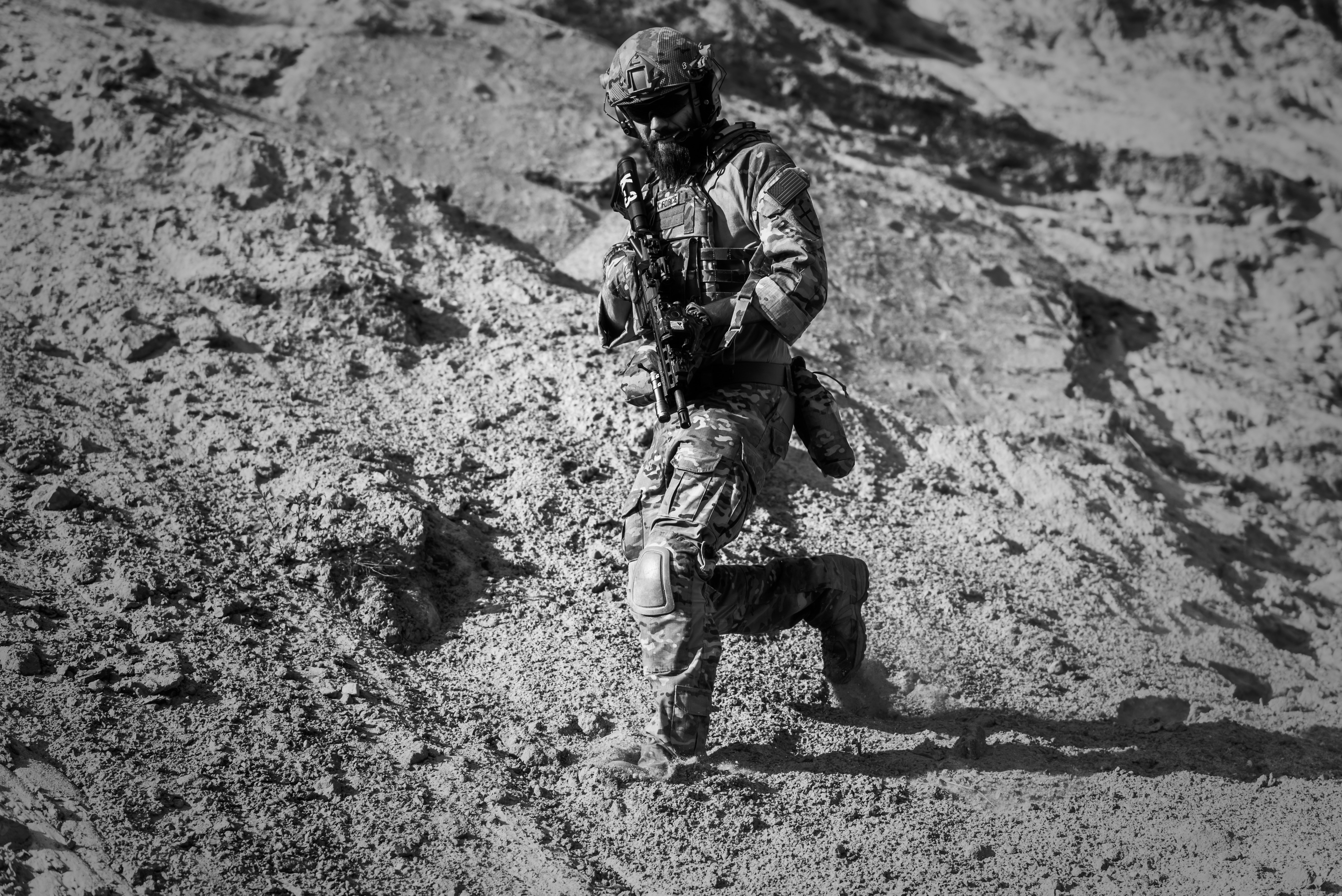 Man in army full combat uniform carrying rifle photo